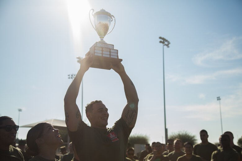 A U.S. Marine stationed at Marine Corps Air Station (MCAS) Yuma, holds up his unit’s trophy after the 3rd Annual Super Squadron event at the MCAS Yuma Memorial Sports Complex January 11, 2019. The Super Squadron is a friendly competition between the various units on station, designed to help strengthen teamwork as well as boost station morale. Marine Air Control Squadron (MACS) 1 won the competition for the 3rd year in a row, with Headquarters & Headquarters Squadron (H&HS) coming in second. (U.S. Marine Corps photo by Cpl. Sabrina Candiaflores)