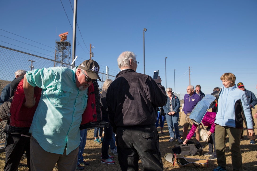 Guests participating in the Marine Corps Air Station (MCAS) Yuma Winter Tours try on K9 gear during a demonstration of the obstacle course, the Marine Corps Martial Arts Program (MCMAP), Explosive Ordinance Detection (EOD), and a military working dog demonstration at various locations on MCAS Yuma, Ariz., Feb. 6, 2019. Col. David A. Suggs, the station commanding officer, resumed the tours in 2018 to strengthen the relationship with the outside community and give them the opportunity to see what the Marines aboard the air station do. (U.S. Marine Corps photo by Sgt. Allison Lotz)