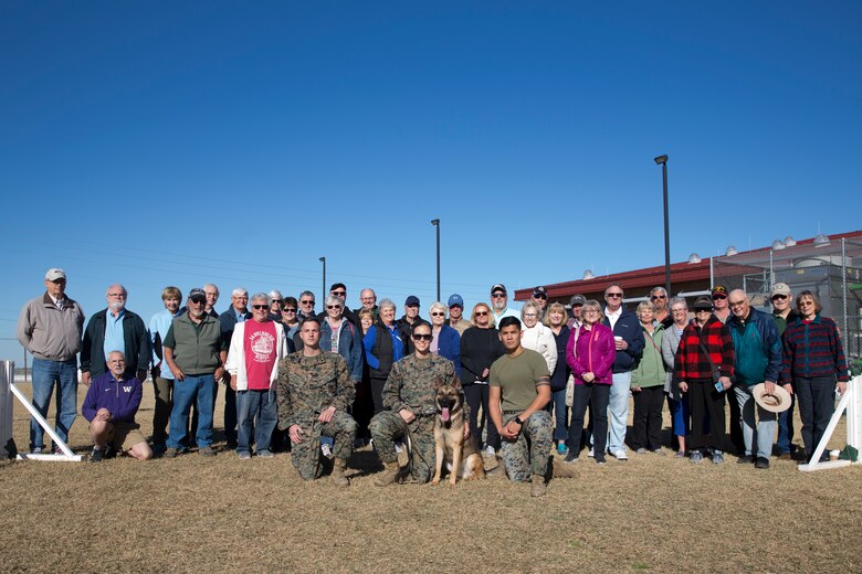 Guests participating in the Marine Corps Air Station (MCAS) Yuma Winter Tours pose for a group photo while viewing a demonstration of the obstacle course, the Marine Corps Martial Arts Program (MCMAP), Explosive Ordinance Detection (EOD), and a military working dog demonstration at various locations on MCAS Yuma, Ariz., Feb. 6, 2019. Col. David A. Suggs, the station commanding officer, resumed the tours in 2018 to strengthen the relationship with the outside community and give them the opportunity to see what the Marines aboard the air station do. (U.S. Marine Corps photo by Sgt. Allison Lotz)