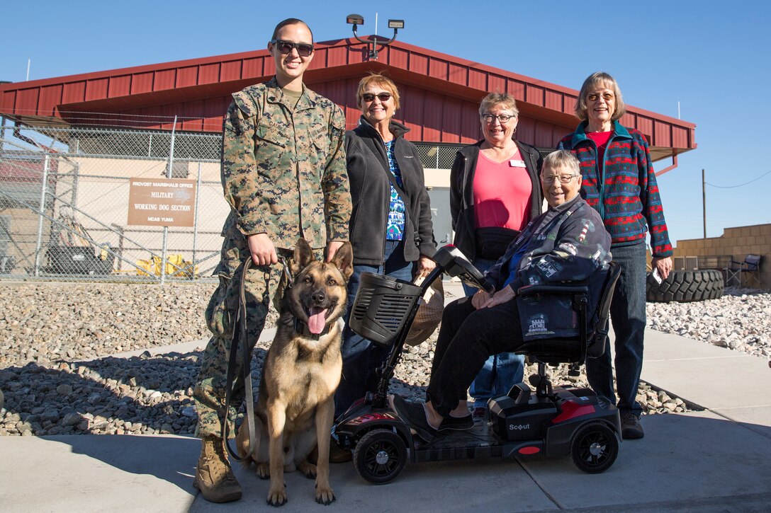 Guests participating in the Marine Corps Air Station (MCAS) Yuma Winter Tours pose for a group photo while viewing a demonstration of the obstacle course, the Marine Corps Martial Arts Program (MCMAP), Explosive Ordinance Detection (EOD), and a military working dog demonstration at various locations on MCAS Yuma, Ariz., Feb. 6, 2019. Col. David A. Suggs, the station commanding officer, resumed the tours in 2018 to strengthen the relationship with the outside community and give them the opportunity to see what the Marines aboard the air station do. (U.S. Marine Corps photo by Sgt. Allison Lotz)