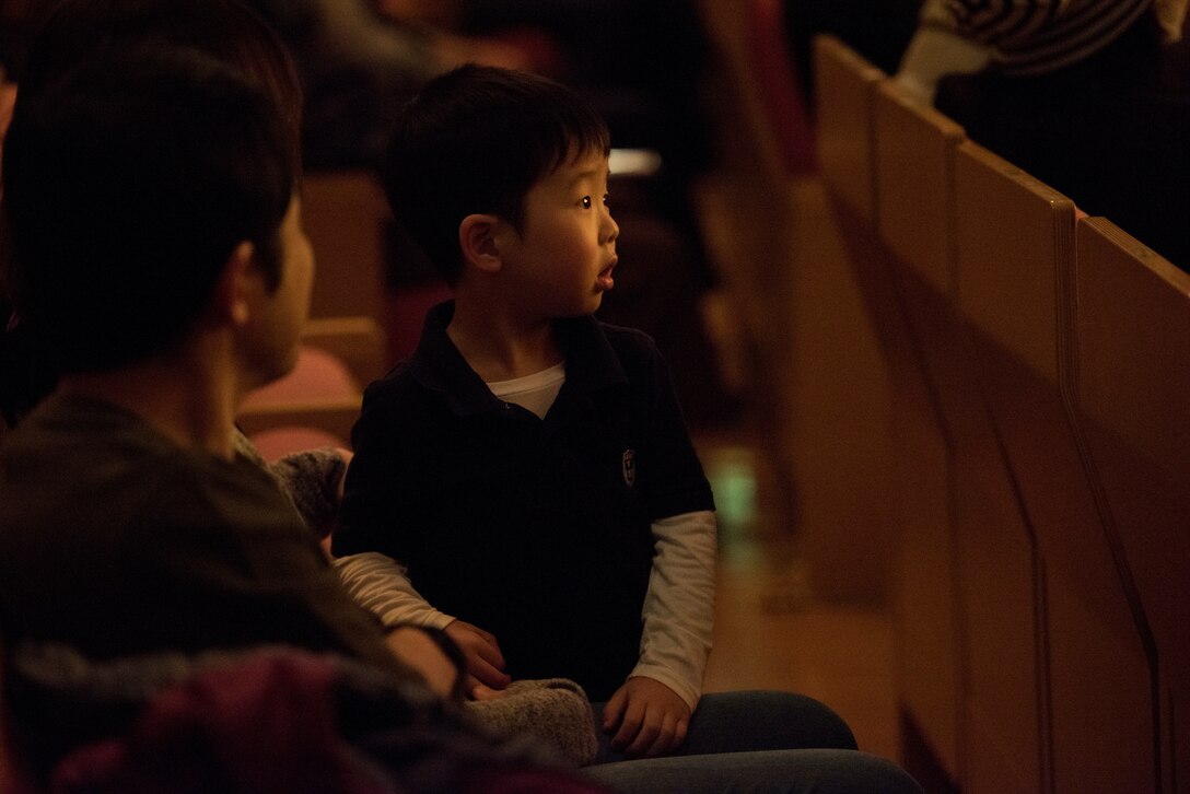 A young concert goer watches the performance during the Japan-U.S. Joint Concert Feb. 24, 2019, at the Hamura Learning Center in Hamura, Tokyo, Japan. The concert included various jazz, big band, and orchestra performance numbers by the USAF Band of the Pacific and the Hamura Daiichi Jr. High School Band. (U.S. Air Force photo by Senior Airman Donald Hudson)