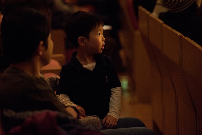 A young concert goer watches the performance during the Japan-U.S. Joint Concert Feb. 24, 2019, at the Hamura Learning Center in Hamura, Tokyo, Japan. The concert included various jazz, big band, and orchestra performance numbers by the USAF Band of the Pacific and the Hamura Daiichi Jr. High School Band. (U.S. Air Force photo by Senior Airman Donald Hudson)