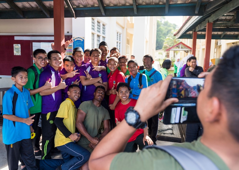 KOTA KINABALU, Malaysia (Feb. 25, 2019) – Lance Cpl. Daniel Notice, from Florissant, Miss., with the 31st Marine Expeditionary Unit (MEU) poses with students from the Sekolah Menengah Kebangsaan Inanam High School during a cultural exchange and community service event.