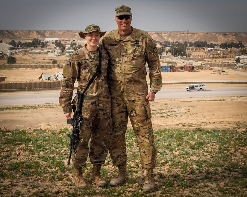 U.S. Army Chief Warrant Officer 5 Joseph Lemens, a helicopter maintenance test pilot assigned to the 935th Aviation Support Battalion, Missouri National Guard, and his daughter U.S. Army 1st. Lt. Jordan Lemens, a route clearance platoon leader assigned to the 2nd platoon, B Co., 326th Brigade Engineer Battalion, pose together for a family photo at Al Asad Air Base, Iraq, Feb. 7, 2019.