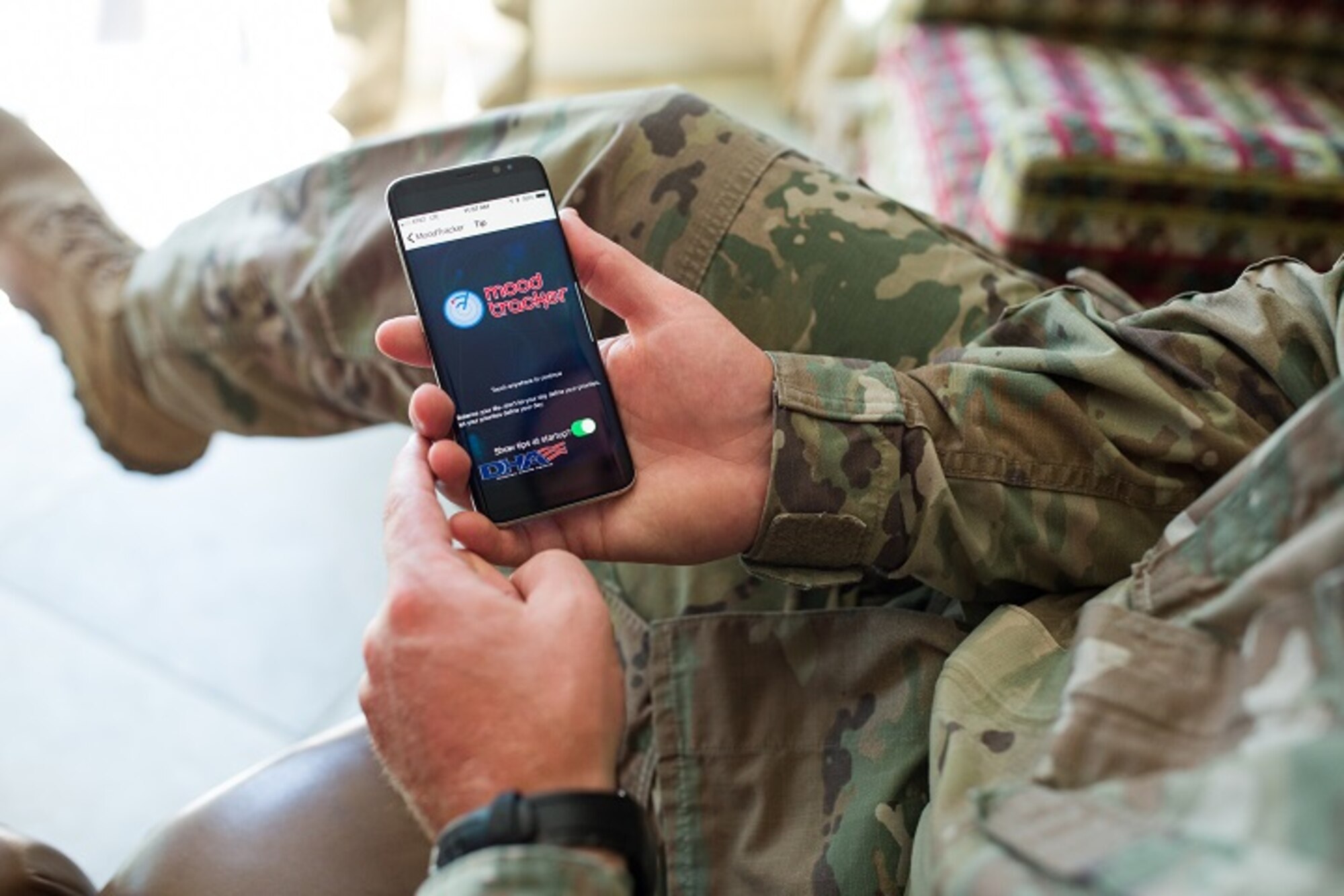 An Army health care provider loads the T2 Mood Tracker mobile app on a mobile device for a demonstration for his patients.