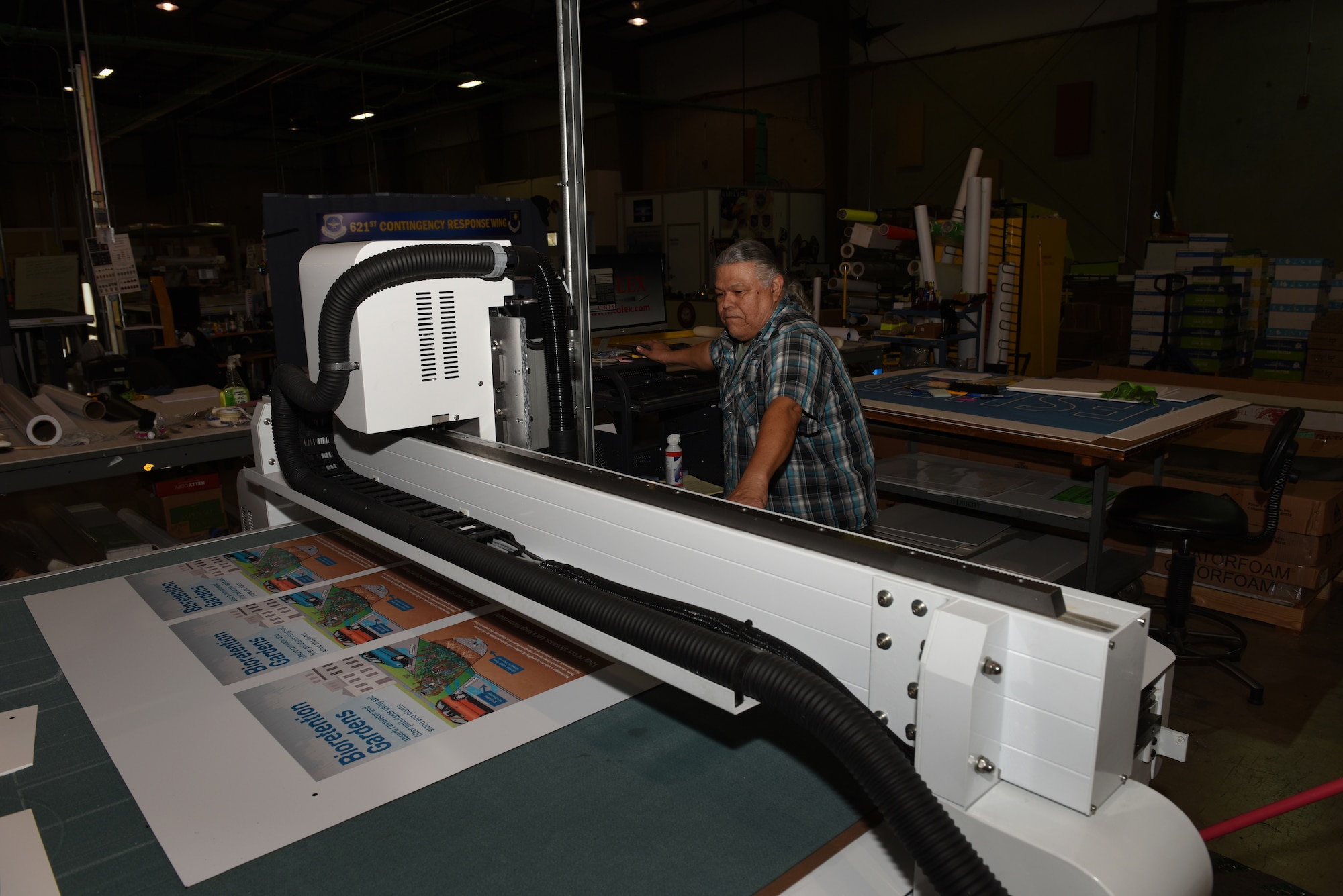 Carlos Castro, Defense Logistics Agency, prepares to cut out several posters Feb. 7, 2019, at Travis Air Force Base, Calif. The Travis DLA facility provides a variety of printing services to federal agencies and government offices. (U.S. Air Force photo by Tech. Sgt. James Hodgman)