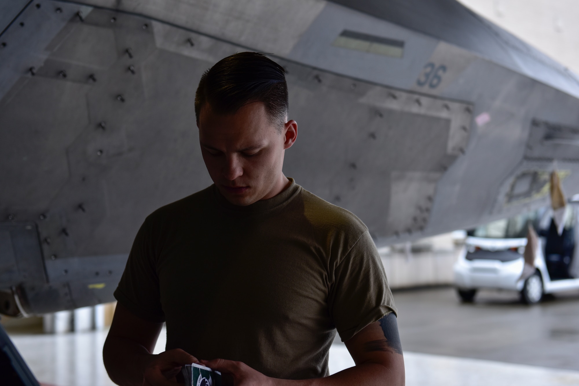 U.S. Air Force Staff Sgt. Jackson Findlay, Tyndall Air Force Base, Fla., 325th Maintenance Squadron crew chief, reviews his notes from the previous days log prior to completing routine maintenance on an F-22 Raptor at Eglin AFB. Fla., Feb. 21, 2019. Some of the F-22s that were stationed at Tyndall AFB were evacuated to Eglin AFB hangars where its’ dedicated crews maintain them until Tyndall hangars are restored. (U.S. Air Force photo by Staff Sgt. Alexandre Montes)
