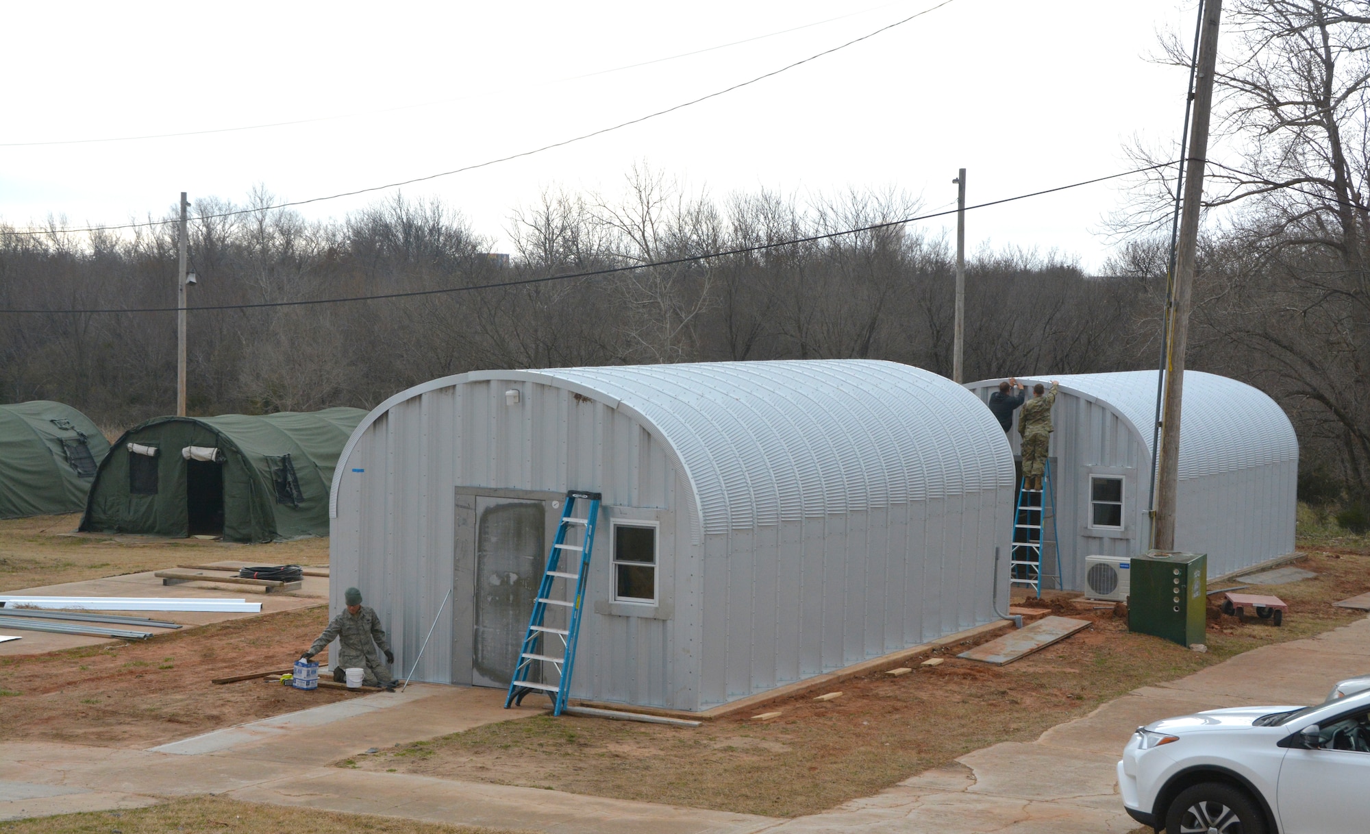 Members of the 507th Civil Engineer Squadron work on the final touches of three new Quonset huts at the Glenwood training area here February 26. Reserve Citizen Airmen partnered with the 72nd Air Base Wing to build the huts and repair some damaged facilities at the training area. The new Quonset huts are more permanent, cheaper, and fully equipped with electric, heating and air. The improvements will make readiness training exercises on the site more efficient, according to members of the wing inspection team. (U.S. Air Force Photo by Maj. Jon Quinlan)