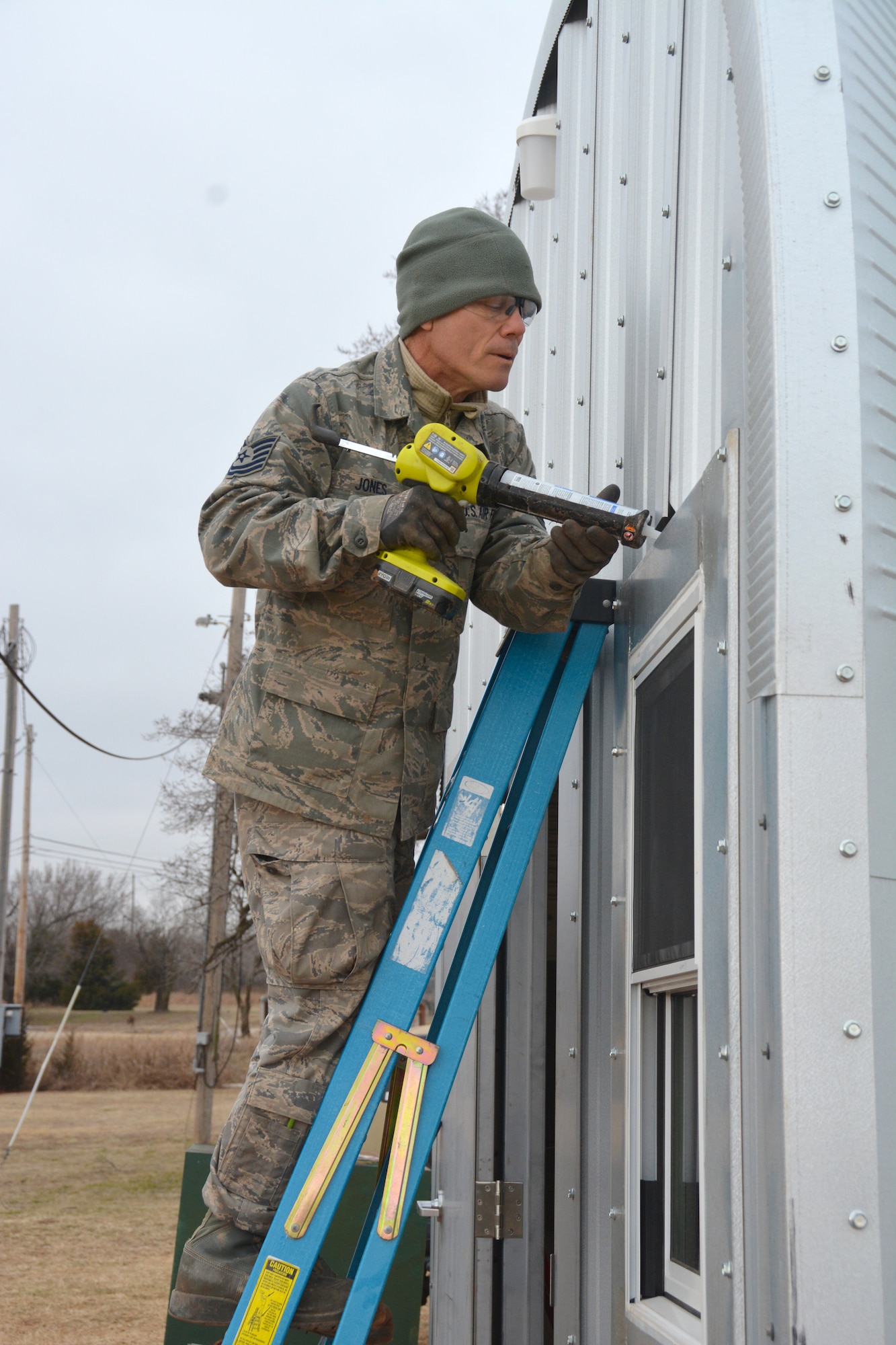 Tech. Sgt. Lyndon Jones, 507th Civil Engineer Squadron works on the final touches of one of the three new Quonset huts at the Glenwood training area here February 26. Reserve Citizen Airmen partnered with the 72nd Air Base Wing to build the huts and repair some damaged facilities at the training area. The new Quonset huts are more permanent, cheaper, and fully equipped with electric, heating and air. The improvements will make readiness training exercises on the site more efficient, according to members of the wing inspection team. (U.S. Air Force Photo by Maj. Jon Quinlan)