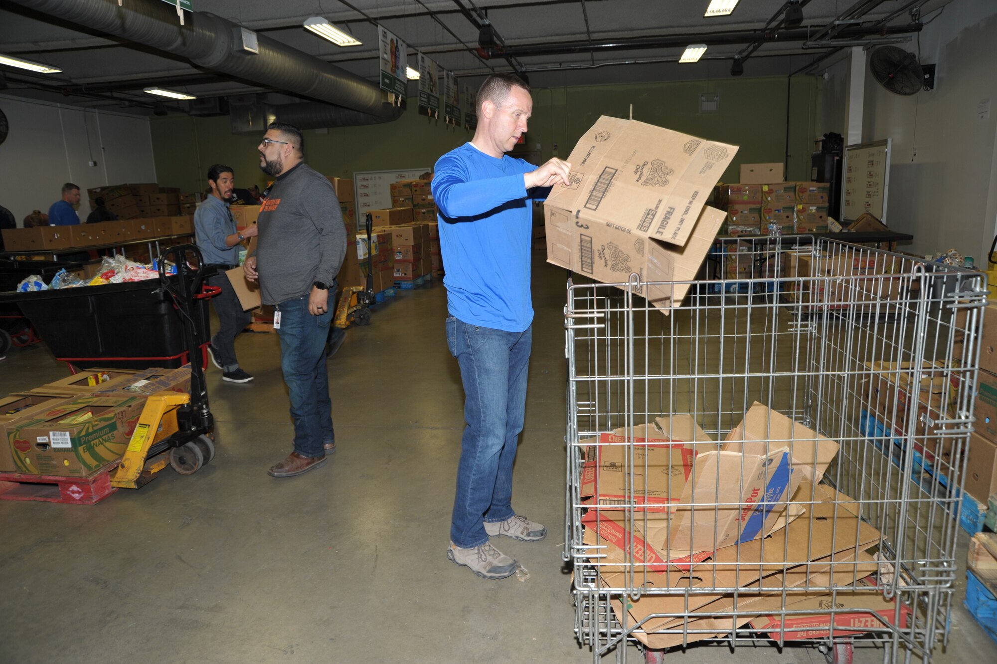 340th Superintendent Chief Master Sgt. Scott Goetze breaks down boxes for recycling during the 340th FTG’s Feb. 22 community outreach event in support of the San Antonio Foodbank. Together, the 340th team and fellow volunteers sorted and packed more than 10,000 pounds of food and non-food items, including pet supplies. (U.S. Air Force photo by Debbie Gildea)
