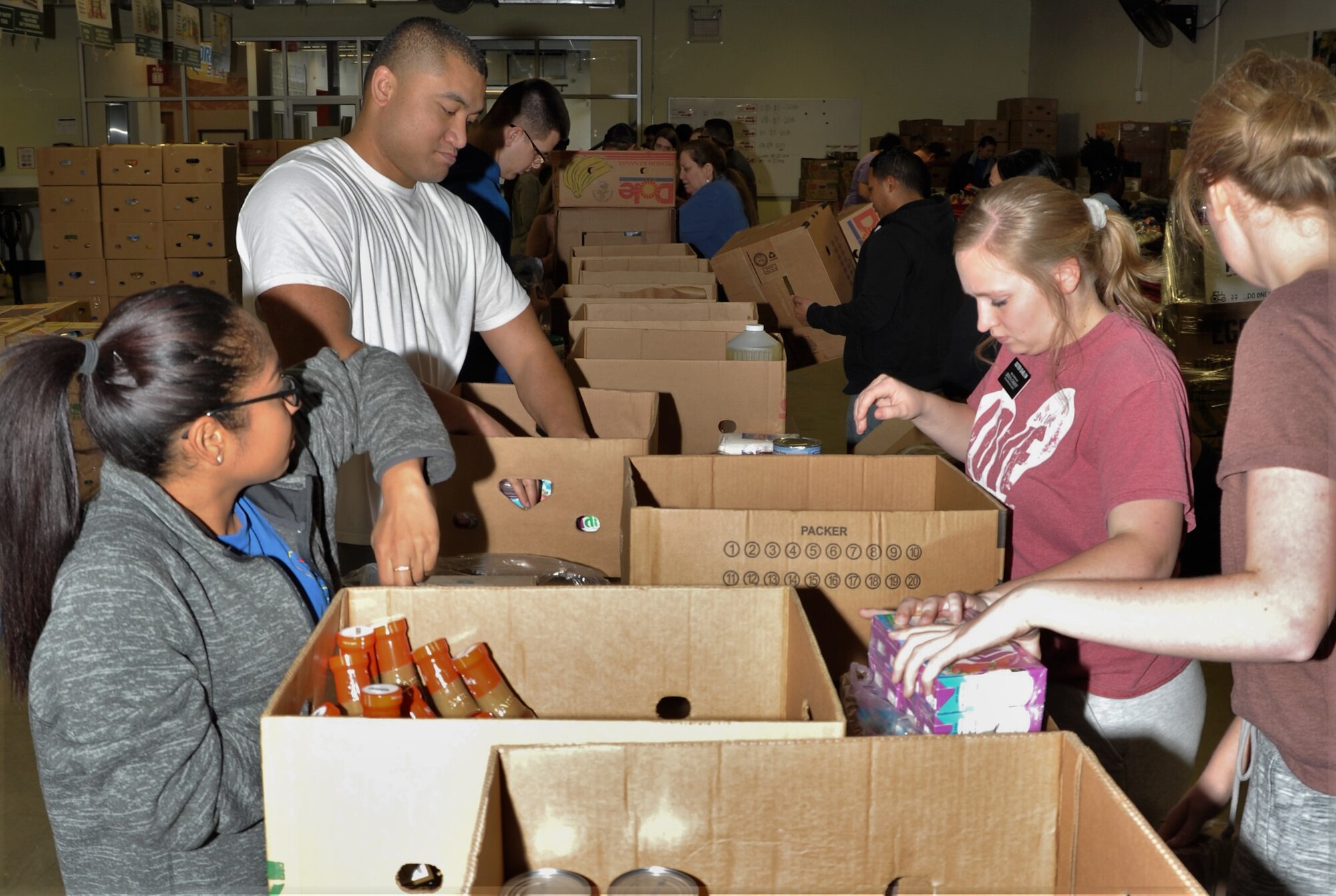 Master Sgt. Natasha Todd (left) and Tech. Sgt. Amosa Farani (white shirt) work alongside volunteers from other San Antonio-area organizations to sort and box food during the 340th FTG’s Feb. 22 community outreach event in support of the San Antonio Foodbank. Together, the 340th team and fellow volunteers sorted and packed more than 10,000 pounds of food. (U.S. Air Force photo by Debbie Gildea)