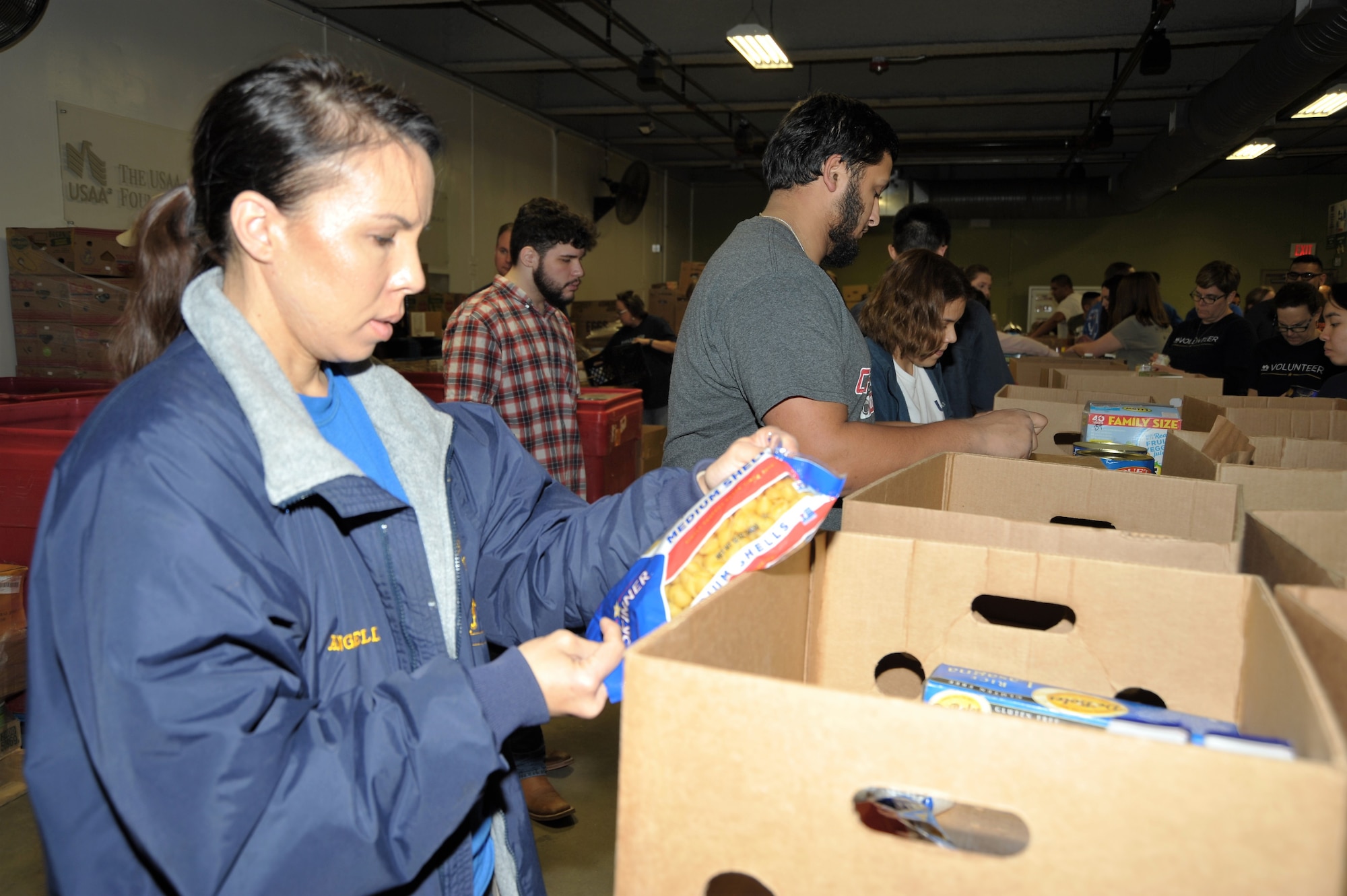 Master Sgt. Angelina Manby, 340th occupational safety manager, checks for expiration dates before packing food in a box during the 340th FTG’s Feb. 22 community outreach event in support of the San Antonio Foodbank. Together, the 340th team and fellow volunteers sorted and packed more than 10,000 pounds of food and non-food items, including pet supplies. (U.S. Air Force photo by Debbie Gildea)