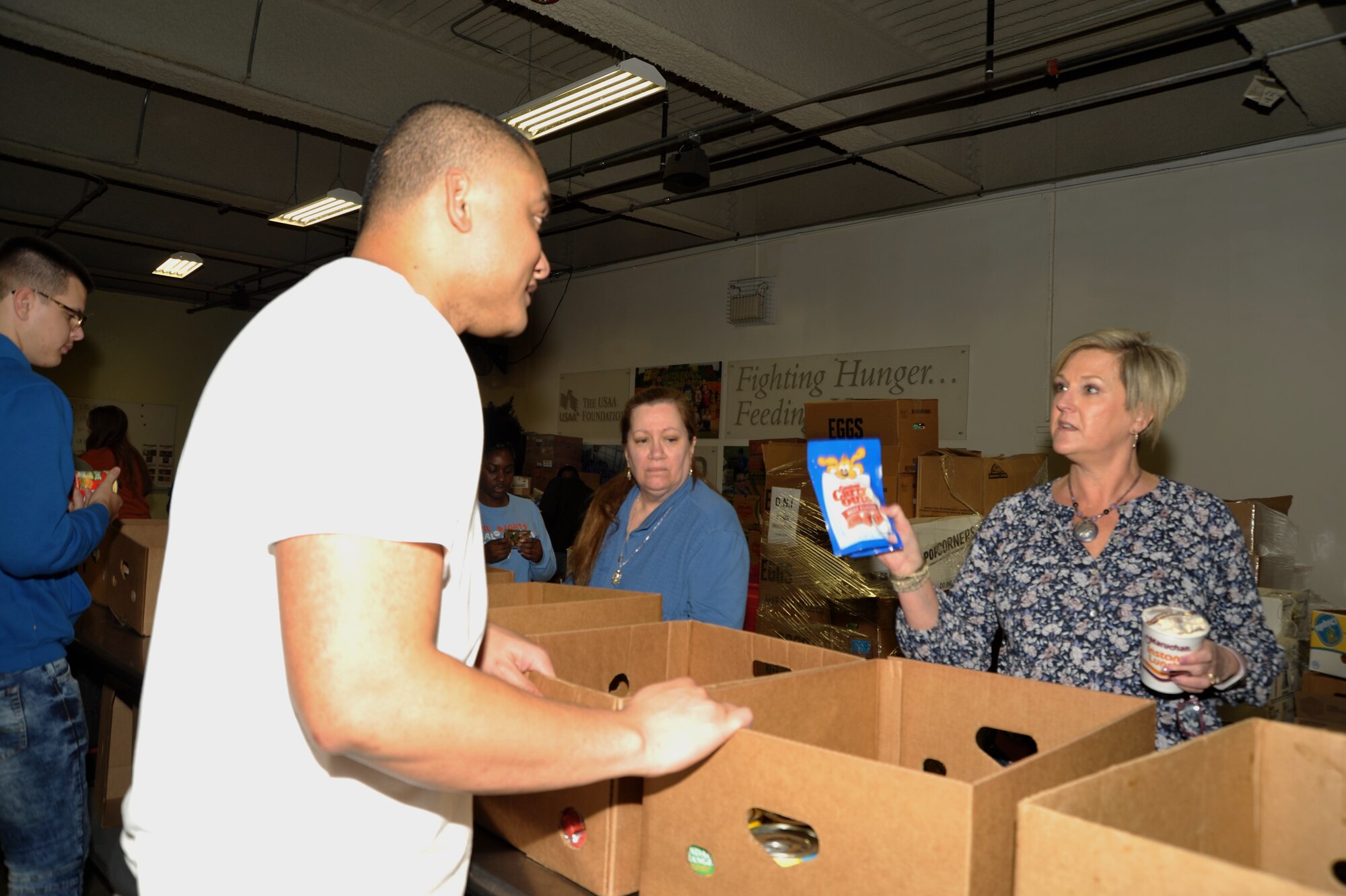 Tech. Sgt. Amosa Farani (married to 340th FTG force management NCO Tech. Sgt. Kassandra Farani) and Jeanne Goetze (married to 340th superintendent Chief Master Sgt. Scott Goetze) discuss the appropriate container for pet supplies during the 340th FTG’s Feb. 22 community outreach event in support of the San Antonio Foodbank. Together, the 340th team and fellow volunteers sorted and packed more than 10,000 pounds of food and non-food items, including pet supplies. (U.S. Air Force photo by Debbie Gildea)