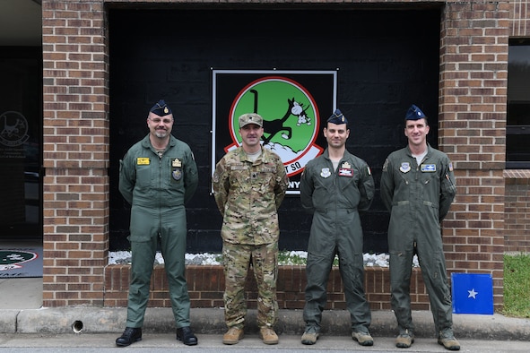 Four men pose for a photo.