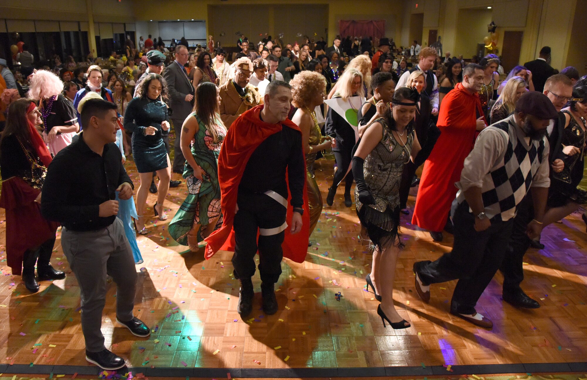 Members of the 81st Medical Group dance during the 31st Annual Krewe of Medics Mardi Gras Ball at the Bay Breeze Event Center on Keesler Air Force Base, Mississippi, Feb. 23, 2019. The Krewe of Medics hosts a yearly ball to give Keesler Medical Center personnel a taste of the Gulf Coast and an opportunity to experience a traditional Mardi Gras, which is celebrated by the local communities. The theme for this year's ball was Hollywood vs. Broadway. (U.S. Air Force photo by Kemberly Groue)