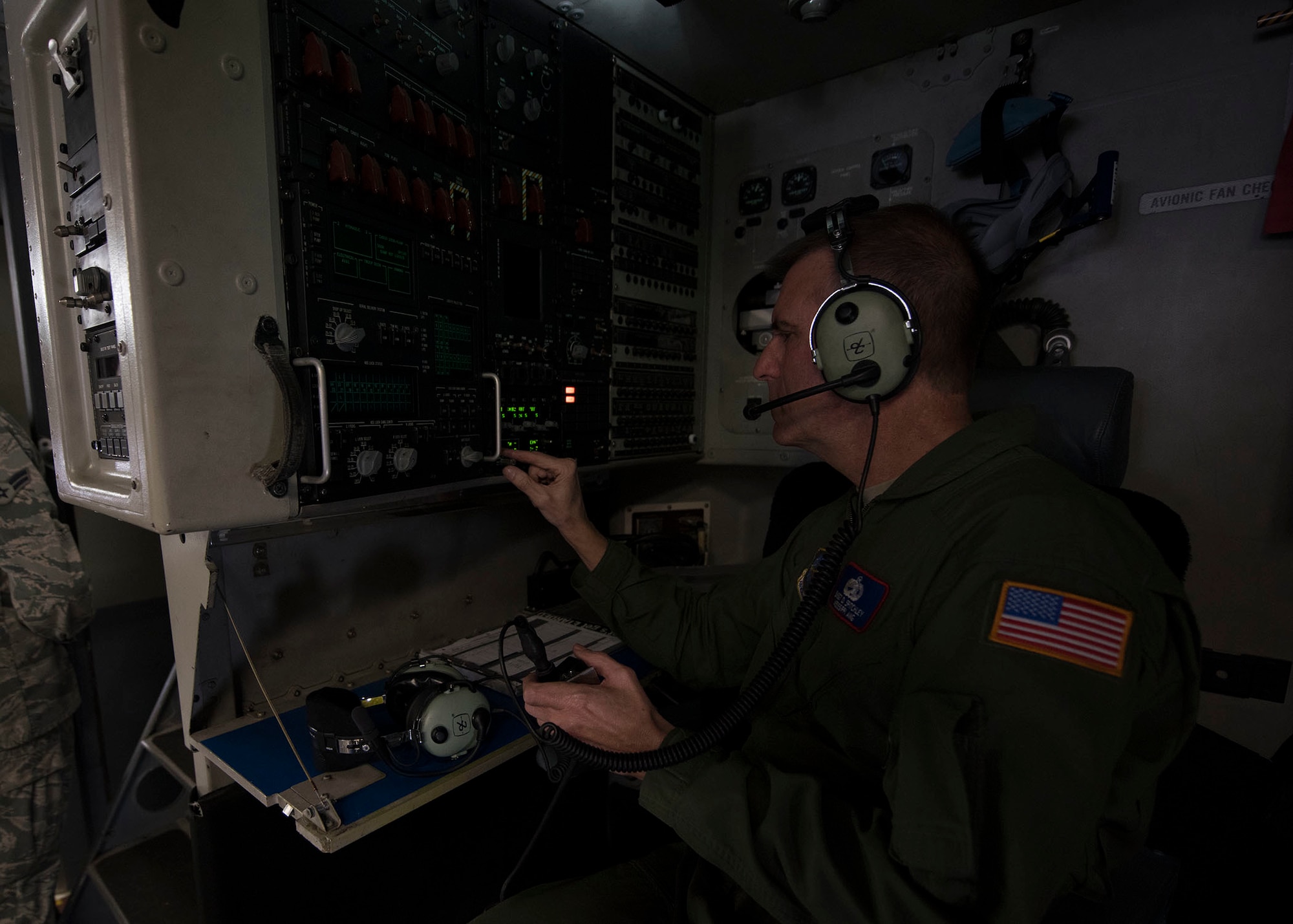 An Airman adjusts dials on a panel while inside a C-17 Globemaster III.