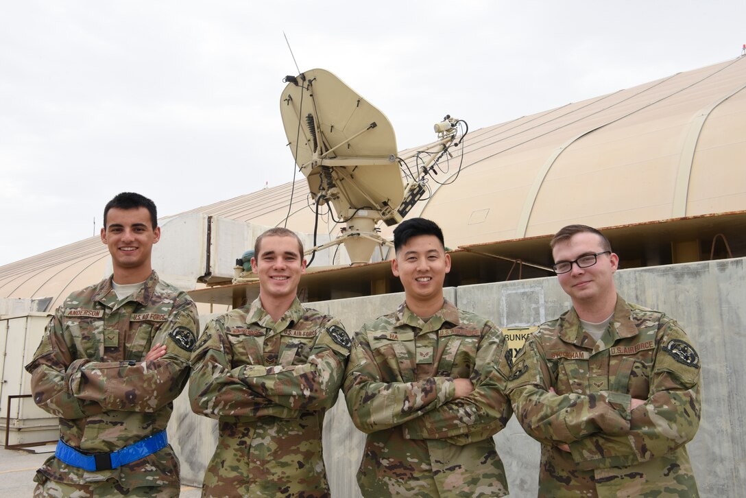 380th Expeditionary Aircraft Maintenance Squadron grounds communication technicians Airman 1st Class Trevor Anderson, Senior Airman Seth Oatridge, Airman 1st Class Michael Ha, and Airman 1st Class Brandon Stockham pose for a group photo in front of their communication satellite, Feb. 17, 2019 at Al Dhafra Air Base, United Arab Emirates.