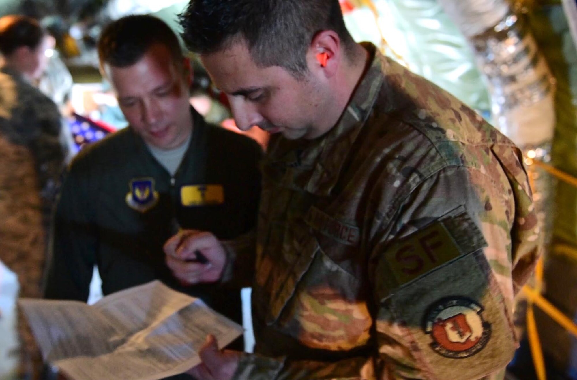 Master Sgt. William Hinchcliff, 31st Security Forces Squadron operations non-commissioned officer in charge, signs his reenlistment paperwork aboard a KC-135 Stratotanker over the Adriatic Sea, Italy, Feb 22, 2019. Hinchcliff reenlisted aboard the aircraft as part of a 31st Fighter Wing incentive flight. (U.S. Air Force photo by Staff Sgt. Tory Cusimano)