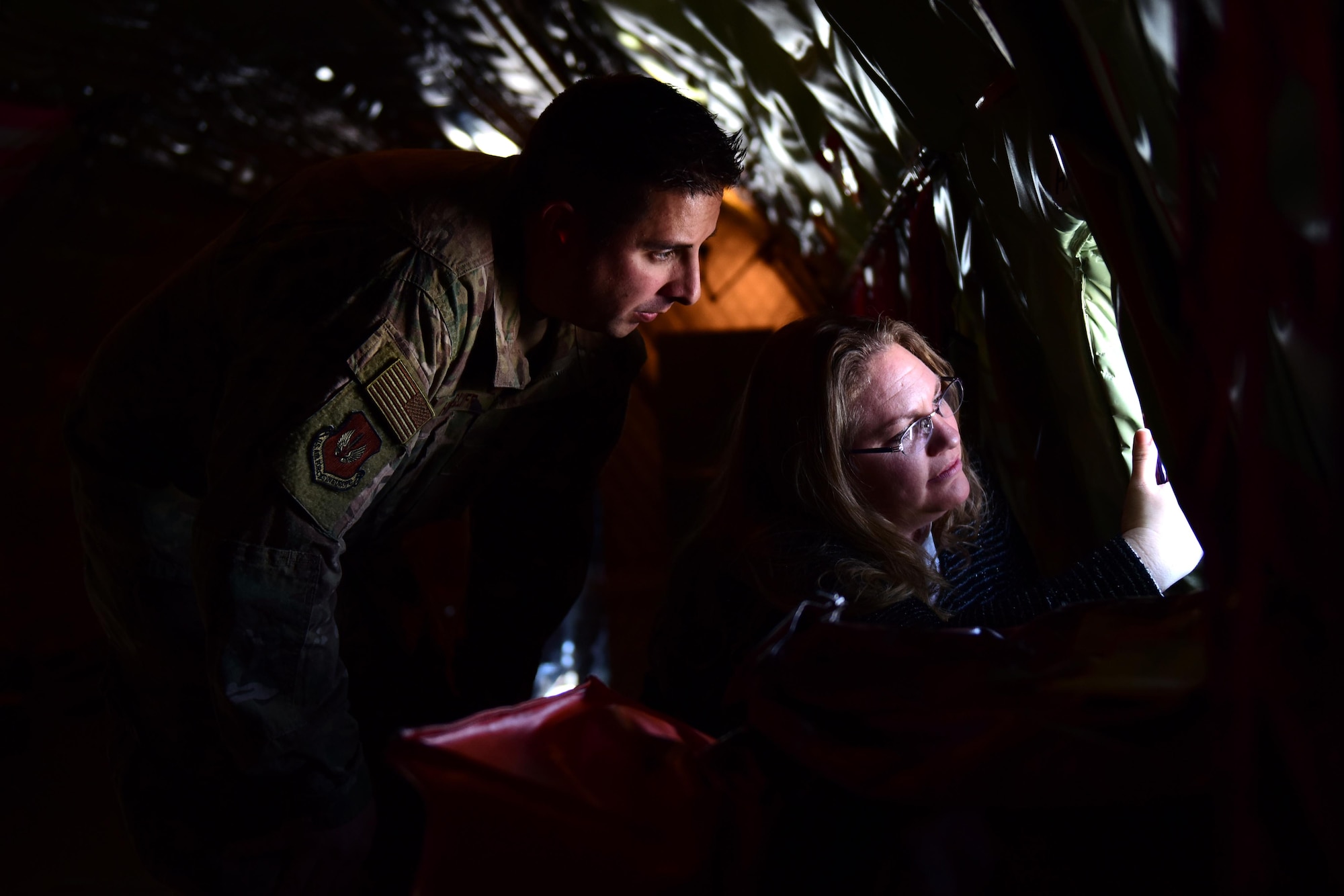 Master Sgt. William Hinchcliff, 31st Security Forces Squadron operations non-commissioned officer in charge, and his wife Kayla peer out a window aboard a KC-135 Stratotanker above the Adriatic Sea, Italy, Feb. 22, 2019. Hinchcliff reenlisted during the flight as a tribute to his father-in-law, a retired KC-135 crew chief. (U.S. Air Force photo by Staff Sgt. Tory Cusimano)