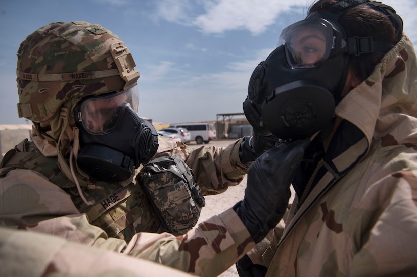 U.S. Army Pvt. Mason Hage (left), 1st Battalion, 43rd Air Defense Artillery (ADA) regiment, 11th ADA Brigade patriot fire control enhanced operator and maintainer, helps U.S. Air Force Staff Sgt. Rikki Sechrist (right), 379th Expeditionary Civil Engineer Squadron (ECES) emergency management Chemical, Biological, Radiological, Nuclear, and high yield explosives (CBRNE) specialist, adjust Mission Oriented Protective Posture (MOPP) gear during a joint decontamination exercise Feb. 22, 2019, at Al Udeid Air Base, Qatar. U.S. Air Force and Army participants from the 379th ECES and the 1-43rd ADA, shared CBRNE best practices, and tested their response proficiency during the training. The event was the conclusion of a four phase training curriculum. (U.S. Air Force photo by Tech. Sgt. Christopher Hubenthal)