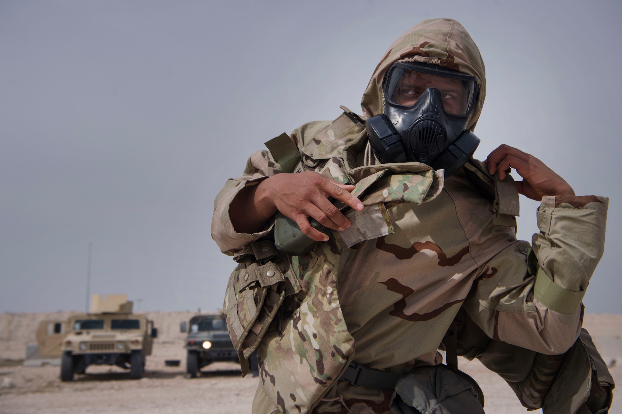 A U.S. Army Soldier of the 1st Battalion, 43rd Air Defense Artillery (ADA) regiment, 11th ADA Brigade, dons Mission Oriented Protective Posture (MOPP) gear during a joint decontamination exercise Feb. 22, 2019, at Al Udeid Air Base, Qatar. U.S. Air Force and Army participants from the 379th Expeditionary Civil Engineer Squadron and the 1-43rd ADA, shared Chemical, Biological, Radiological, Nuclear, and high yield explosives (CBRNE) best practices, and tested their response proficiency during the training. The event was the conclusion of a four phase training curriculum. (U.S. Air Force photo by Tech. Sgt. Christopher Hubenthal)