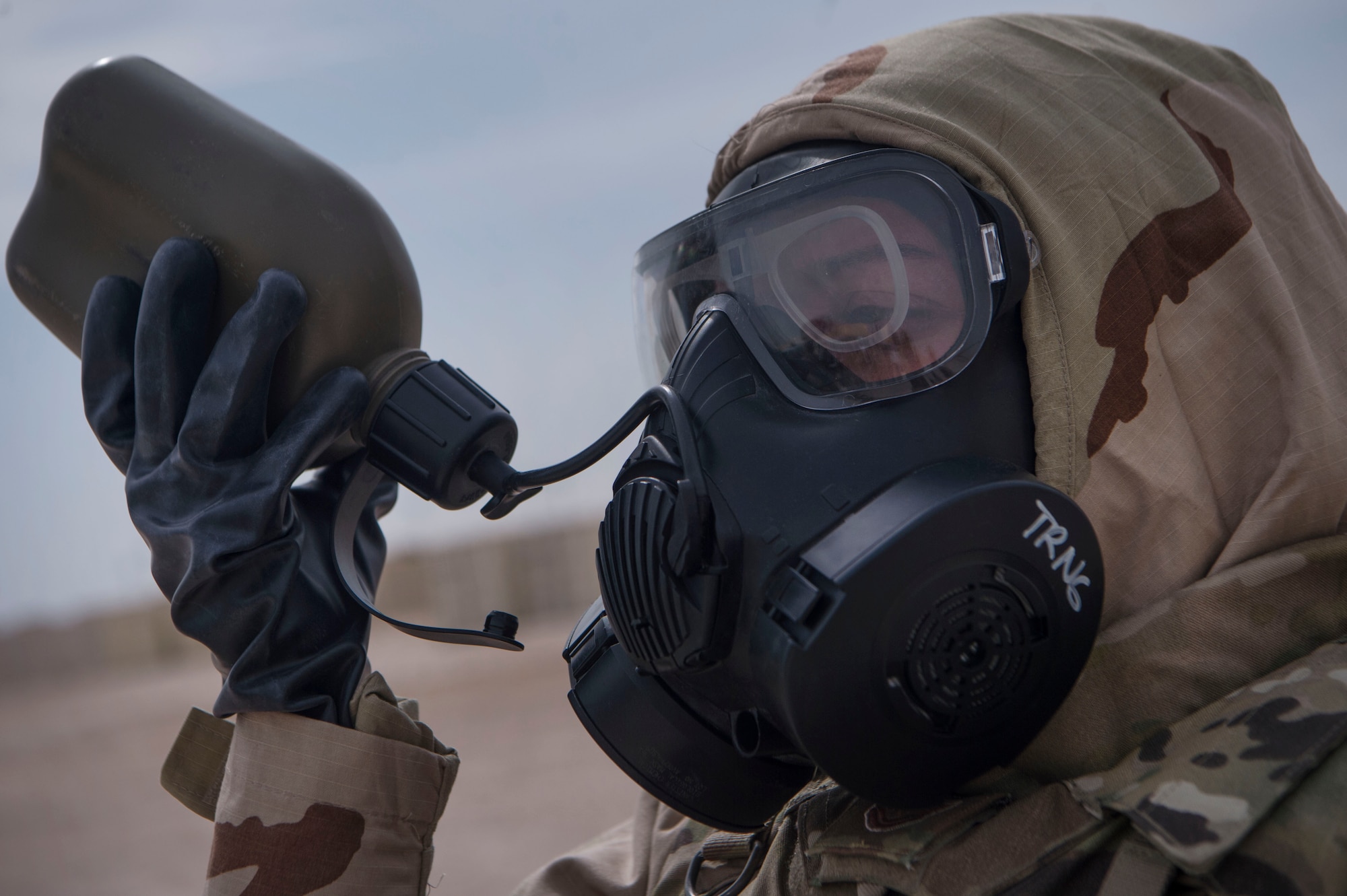 A U.S. Air Force Airman of the 379th Expeditionary Civil Engineer Squadron (ECES) emergency management office, hydrates during a joint decontamination exercise Feb. 22, 2019, at Al Udeid Air Base, Qatar. U.S. Air Force and Army participants from the 379th Expeditionary Civil Engineer Squadron and the 1st Battalion, 43rd Air Defense Artillery regiment, 11th ADA Brigade, shared Chemical, Biological, Radiological, Nuclear, and high yield explosives (CBRNE) best practices, and tested their response proficiency during the training. The event was the conclusion of a four phase training curriculum. (U.S. Air Force photo by Tech. Sgt. Christopher Hubenthal)