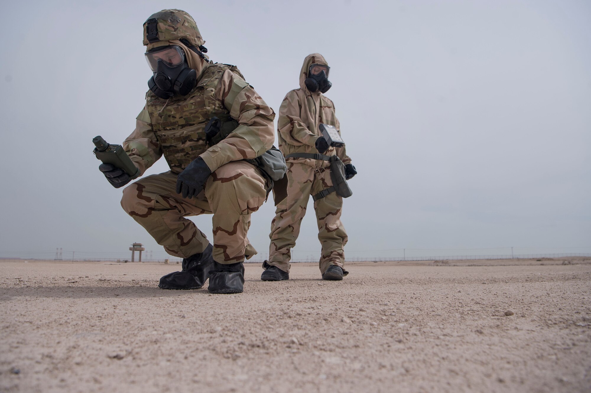 Tech. Sgt. Steven Jefferies (left), and Staff Sgt. Rikki Sechrist (right), both of the 379th Expeditionary Civil Engineer Squadron (ECES) emergency management office, conduct a ground survey during a joint decontamination exercise Feb. 22, 2019, at Al Udeid Air Base, Qatar. U.S. Air Force and Army participants from the 379th ECES and the 1st Battalion, 43rd Air Defense Artillery regiment, 11th ADA Brigade, shared Chemical, Biological, Radiological, Nuclear, and high yield explosives (CBRNE) best practices, and tested their response proficiency during the training. The event was the conclusion of a four phase training curriculum. (U.S. Air Force photo by Tech. Sgt. Christopher Hubenthal)