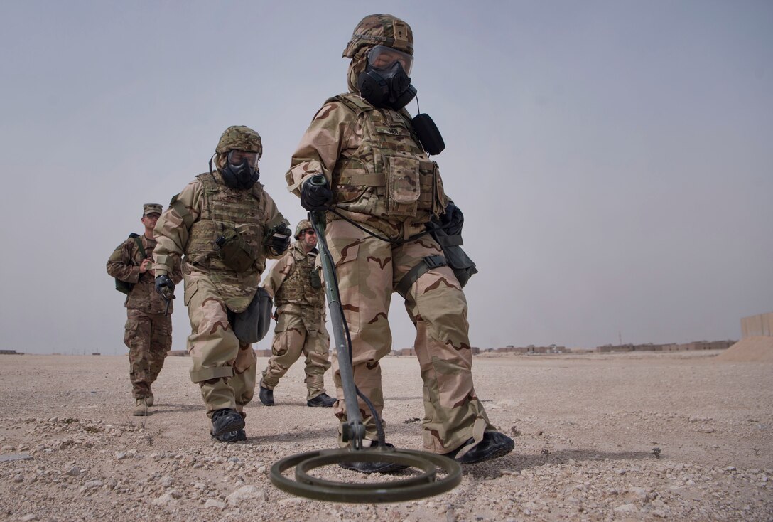 U.S. Army Pfc. Diamond Her (center), 1st Battalion, 43rd Air Defense Artillery (ADA) regiment, 11th ADA Brigade unit supply specialist, and U.S. Air Force Master Sgt. Brett Sanchez, 379th Expeditionary Civil Engineer Squadron (ECES) emergency management Chemical, Biological, Radiological, Nuclear, and high yield explosives (CBRNE) response NCO in charge, conduct a ground survey during a joint decontamination exercise Feb. 22, 2019, at Al Udeid Air Base, Qatar. U.S. Air Force and Army participants from the 379th ECES and the 1-43rd ADA, shared Chemical, Biological, Radiological, Nuclear, and high yield explosives (CBRNE) best practices, and tested their response proficiency during the training. The event was the conclusion of a four phase training curriculum. (U.S. Air Force photo by Tech. Sgt. Christopher Hubenthal)