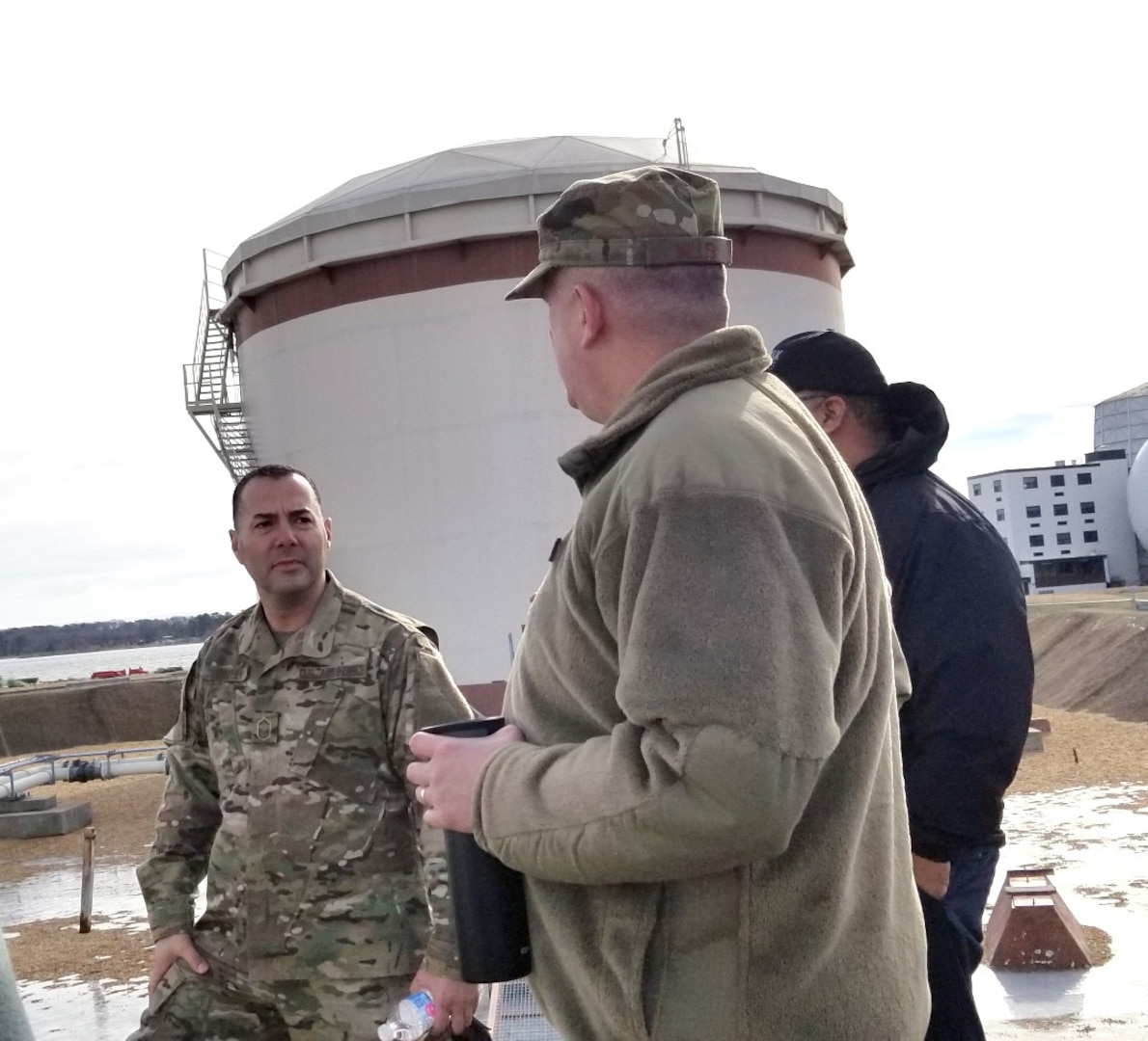 men in uniform stand by fuel tanks