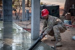 Spc. Edward McClure, 176th Engineer Company, Washington National Guard, uses his experience as a civilian contractor to put the finishing touches on the concrete slab at the Bankoh-I-Duan School in the Tak Province, Kingdom of Thailand, Jan. 30, 2019