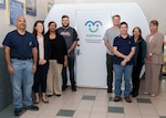 Naval Surface Warfare Center Panama City Division (NSWC PCD) and Lynxnet personnel pose for a photo in front of one of three new Mamava nursing pods. Pictured from left to right: Benji Garcia, Danielle Kinkade, Carmelita Martin, Steve Blackmon, Tyler Dennis, Jason Zimmerman, Robbie Kurth, and Mary Hulgan. The nursing pods are designed to create a comfortable nursing environment for working mothers.