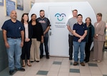 Naval Surface Warfare Center Panama City Division (NSWC PCD) and Lynxnet personnel pose for a photo in front of one of three new Mamava nursing pods. Pictured from left to right: Benji Garcia, Danielle Kinkade, Carmelita Martin, Steve Blackmon, Tyler Dennis, Jason Zimmerman, Robbie Kurth, and Mary Hulgan. The nursing pods are designed to create a comfortable nursing environment for working mothers.