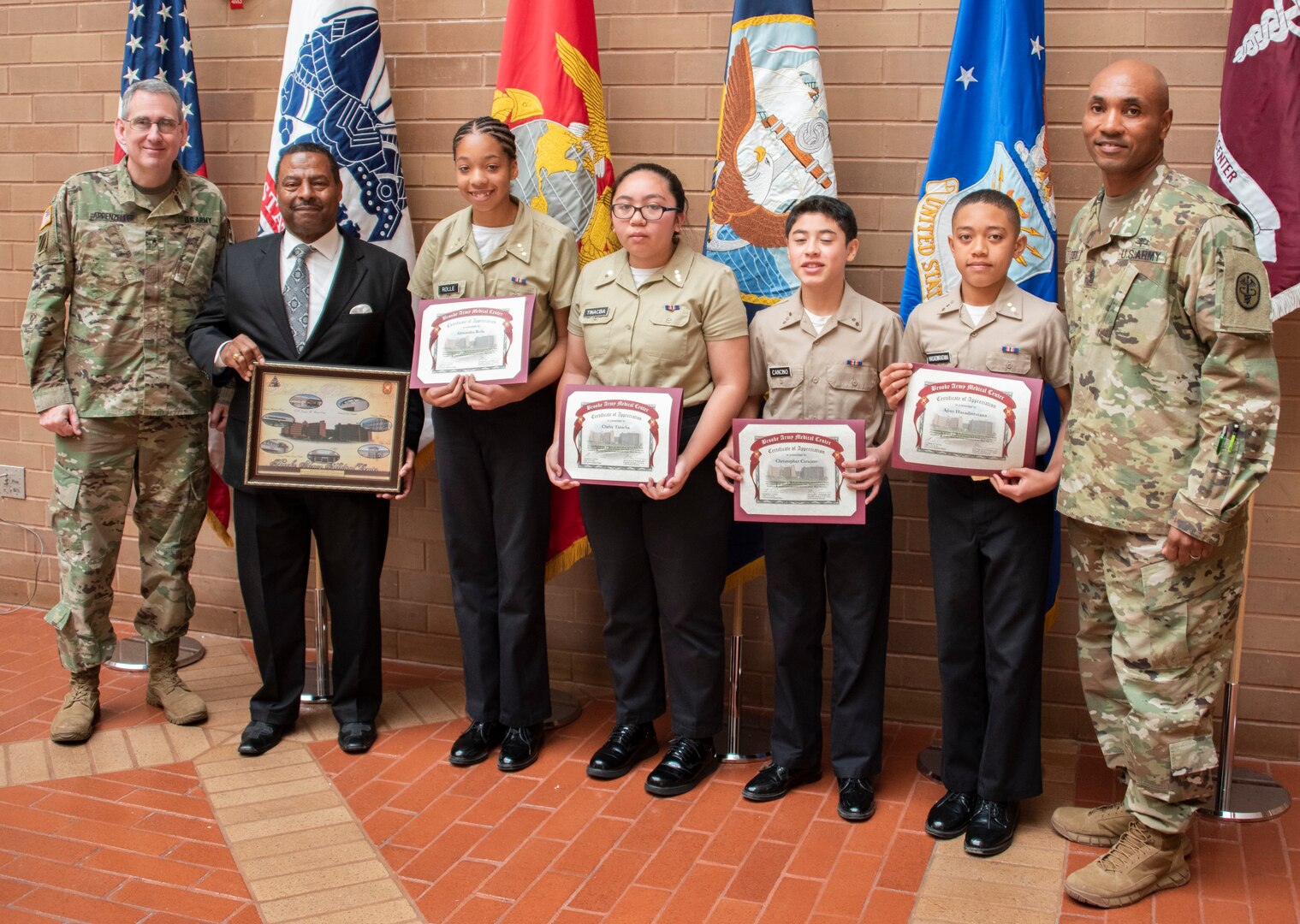 Brooke Army Medical Center Commanding General Brig. Gen. George Appenzeller (left) and Command Sgt. Maj. Thomas Oates (right) present guest speaker, retired Army Lt. Col. Otis Mitchell and Robert G. Cole Middle School students a token of appreciation for participating in BAMC’s Black History Month observance Feb. 20, 2019.