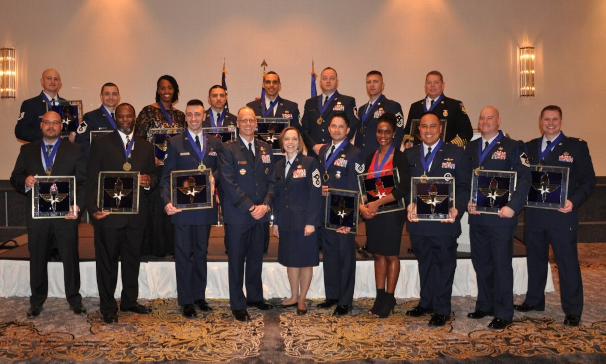 Winners of the 2018 Air Education and Training Command Outstanding Airmen of the Year awards stand with Maj. Gen. Mark Weatherington (third from left) and command chief of AETC, Chief Master Sgt. Juliet Gudgel (fourth from left) during a ceremony in Orlando, Fla., Feb. 26, 2019.  A total of 21 Airmen were recognized at the event and move on to the the Air Force-level competition. (U.S. Air Force photo by 1st Lt. Kayshel Trudell)