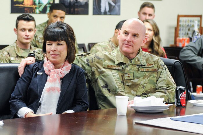 Major General Sam Barrett, 18th Air Force commander, holds his wife, Kelly, while Staff Sgt. Trevor Childs, assigned to Joint Base Charleston’s protocol office, plays “Can’t Help Falling in Love” by Elvis Presley for the family members present during a luncheon Feb. 14, 2019, in the 437th Airlift Wing conference room on Joint Base Charleston, S.C.