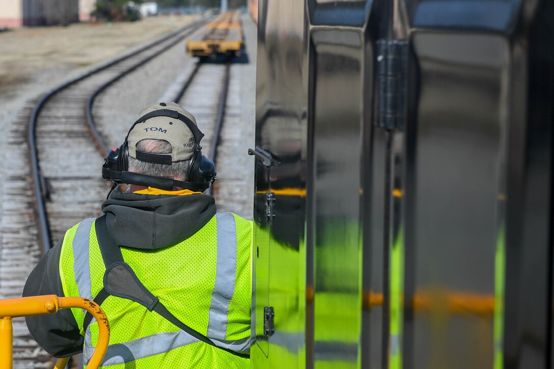 Thomas DeRosier, 733rd Logistics Readiness Squadron, Transportation section, utility rail branch locomotive engineer, guides the railcar driver into a cargo yard at Joint Base Langley-Eustis, Virginia, Feb. 15, 2019. Railroads have been an integral part of military operations dating back to the Civil War and all the way up to the Korean War. (U.S. Air Force photo by Senior Airman Derek Seifert)