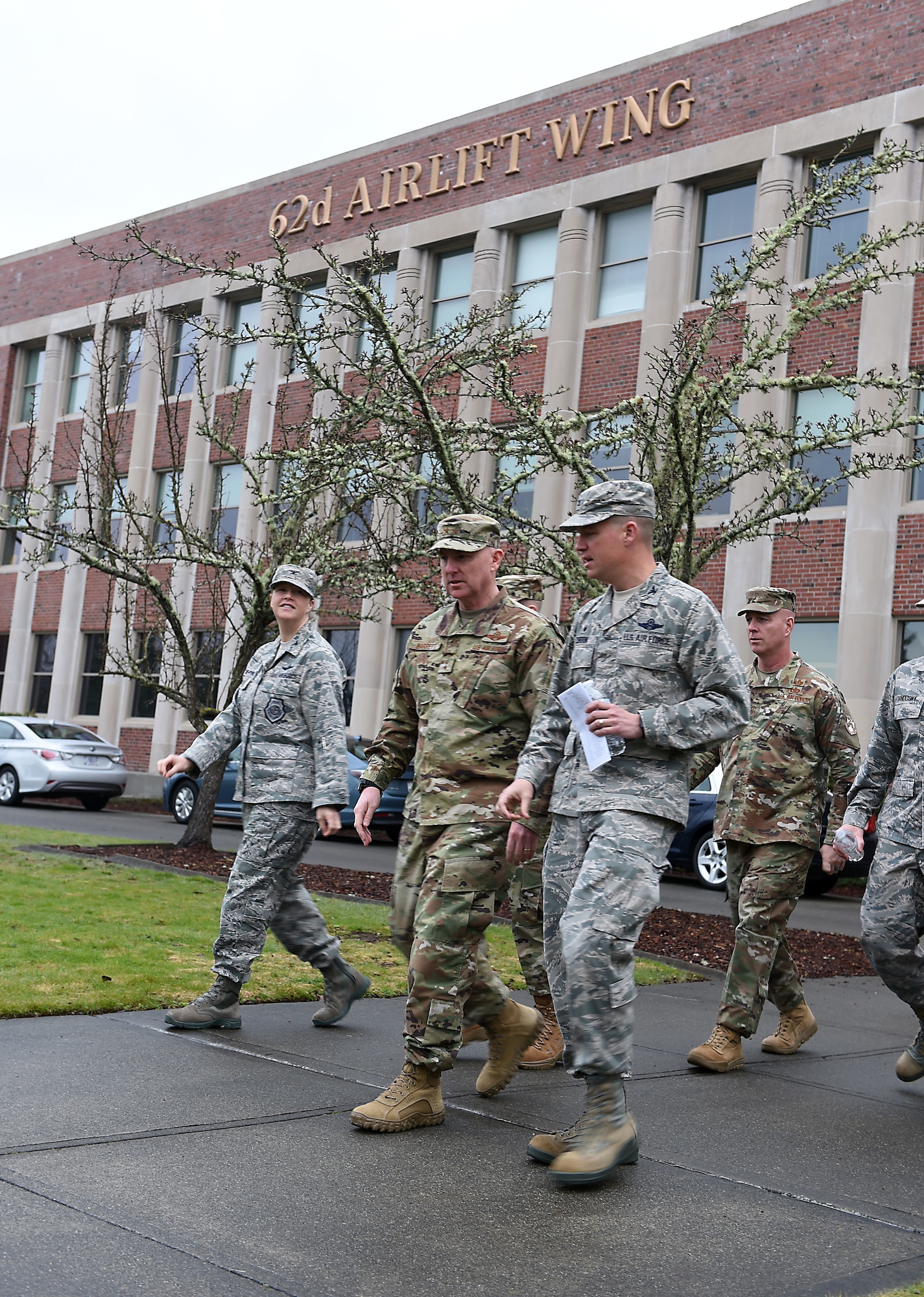 Col. Erin Staine-Pyne, 62nd Airlift Wing vice commander, Maj. Gen. Sam Barrett, 18th Air Force commander, Col. Scovill Currin, 62nd Airlift Wing commander, Chief Master Sgt. Chris Simpson, 18th Air Force command chief master sergeant, exit the 62nd Airlift Wing headquarters to see more of Joint Base Lewis-McChord, Wash., Feb. 20, 2019.
