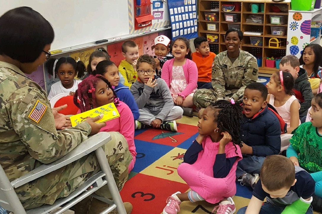 A service member reads to children.