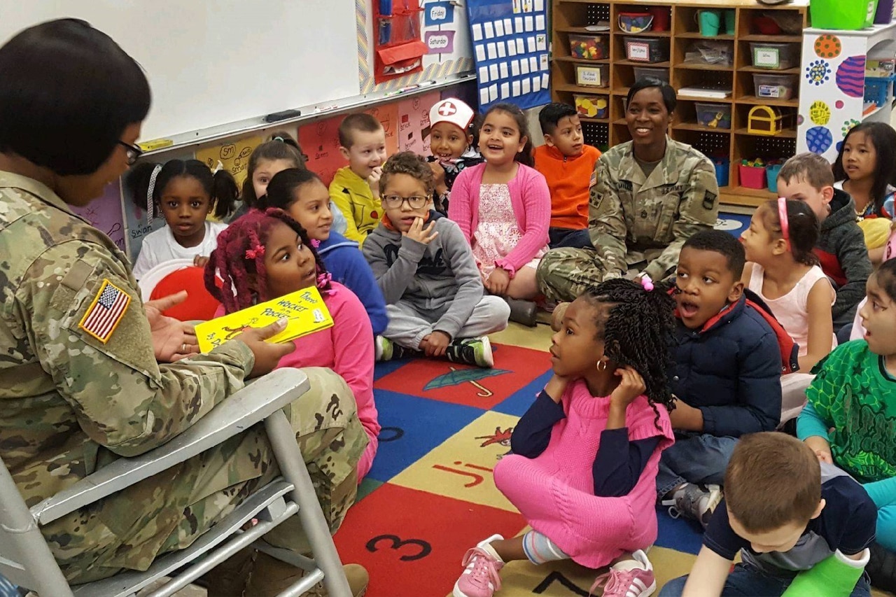 A service member reads to children.