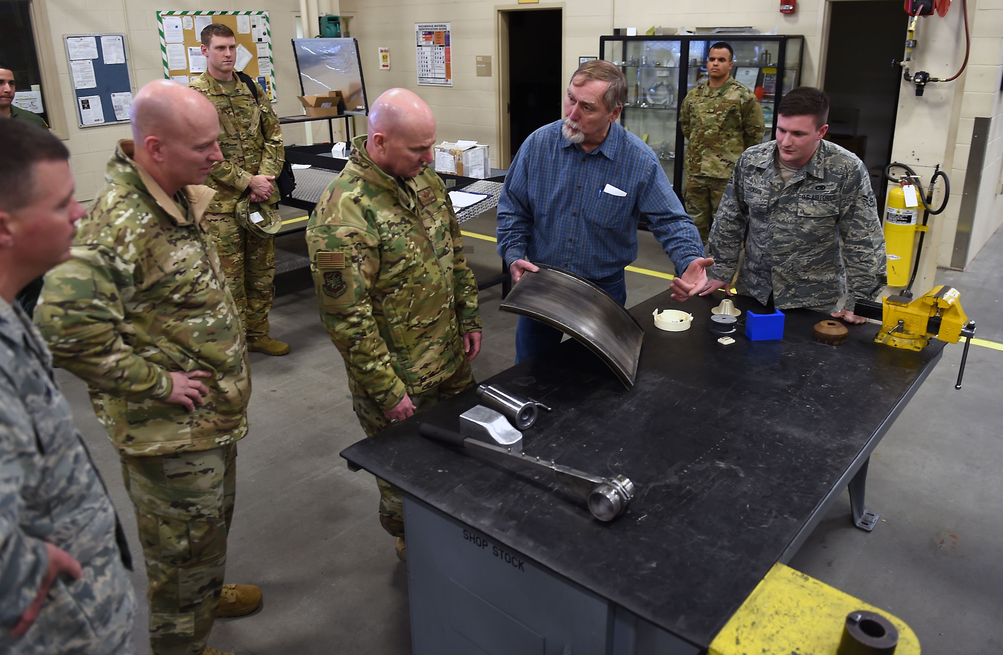 Chief Master Sgt. Chris Simpson, 18th Air Force command chief master sergeant, and Maj. Gen. Sam C. Barrett, 18th Air Force commander, are given a presentation by Will Nelson, 62nd Maintenance Squadron Metals shop foreman, on Joint Base Lewis-McChord, Wash., Feb. 21, 2019.