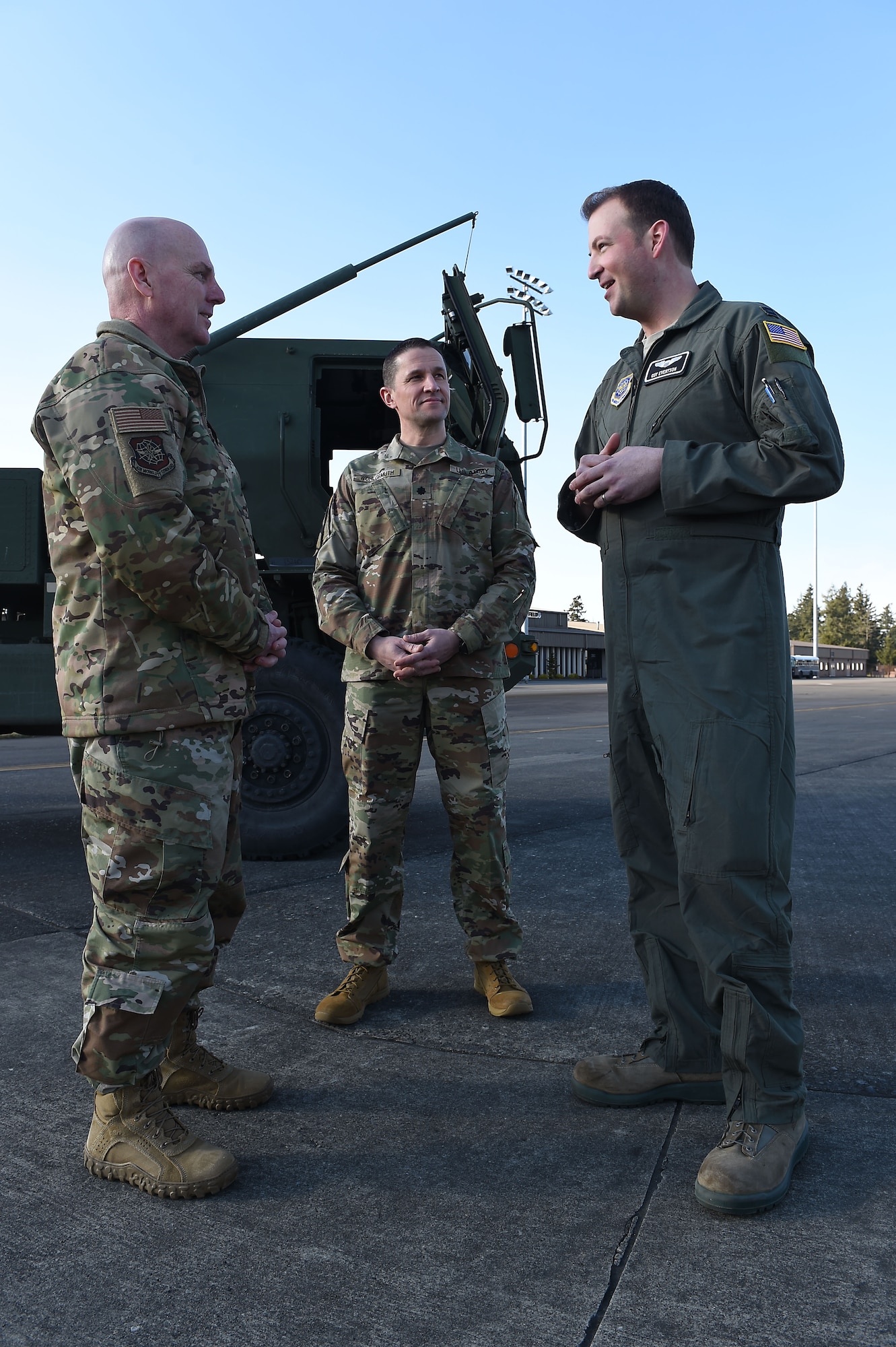 Maj. Gen. Sam C. Barrett, 18th Air Force commander, U.S. Army Lt. Col. Marty Wohlgemuth, 5-3 Field Artillery Battalion commander, listen while Capt. Guy Evertson, 8th Airlift Squadron pilot, shares the applicability of joint-basing to real-world skills development on Joint Base Lewis-McChord, Wash., Feb. 21, 2019.