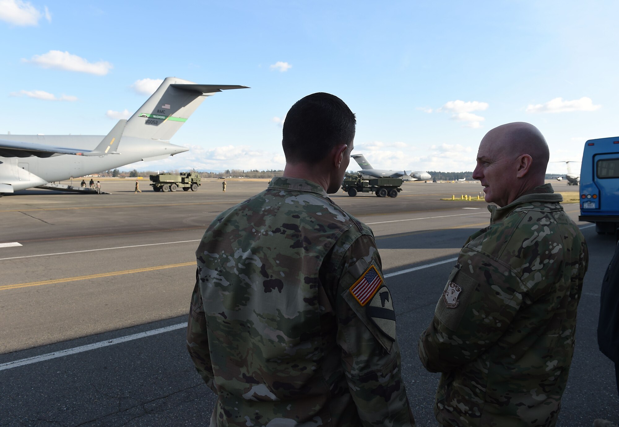 Maj. Gen. Sam Barrett, 18th Air Force commander, right, observes as U.S. Army high mobility artillery rocket systems (HIMARS) offload from a McChord C-17 Globemaster III on Joint Base Lewis-McChord, Wash., Feb. 21, 2019.