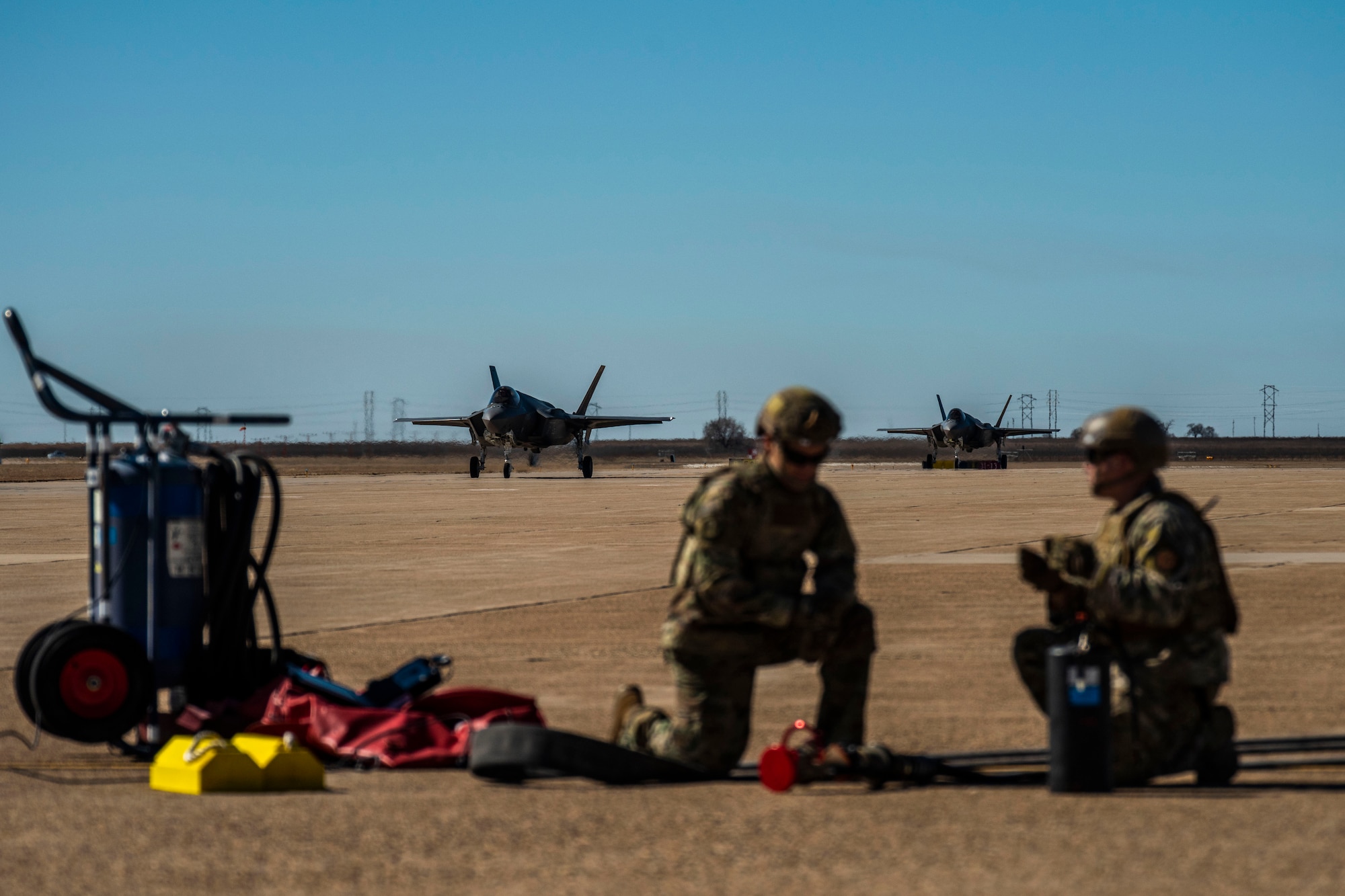 Two Airmen from the 27th Special Operations Logistics Readiness Squadron prepare for incoming F-35A aircraft during training for a Forward Area Refueling Point operation at Cannon Air Force Base, N.M., Feb. 26, 2019. This was the first time FARP training was conducted with the F-35A from a C-130. (U.S. Air Force photo by Staff Sgt. Luke Kitterman)