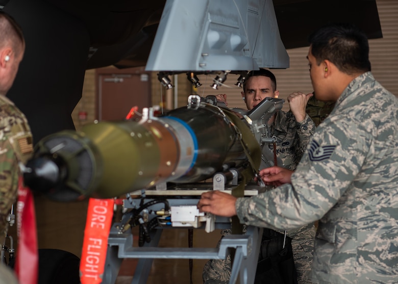 Senior Airman Levi Aydt, 56th Component Maintenance Squadron load crew member, directs the jammer driver to position dummy munitions on an external pylon, Feb. 13, 2019 at Luke Air Force Base, Ariz. The F-35A Lightning II can have external pylons installed for additional munitions while in combat. (U.S. Air Force photo by Airman 1st Class Aspen Reid)