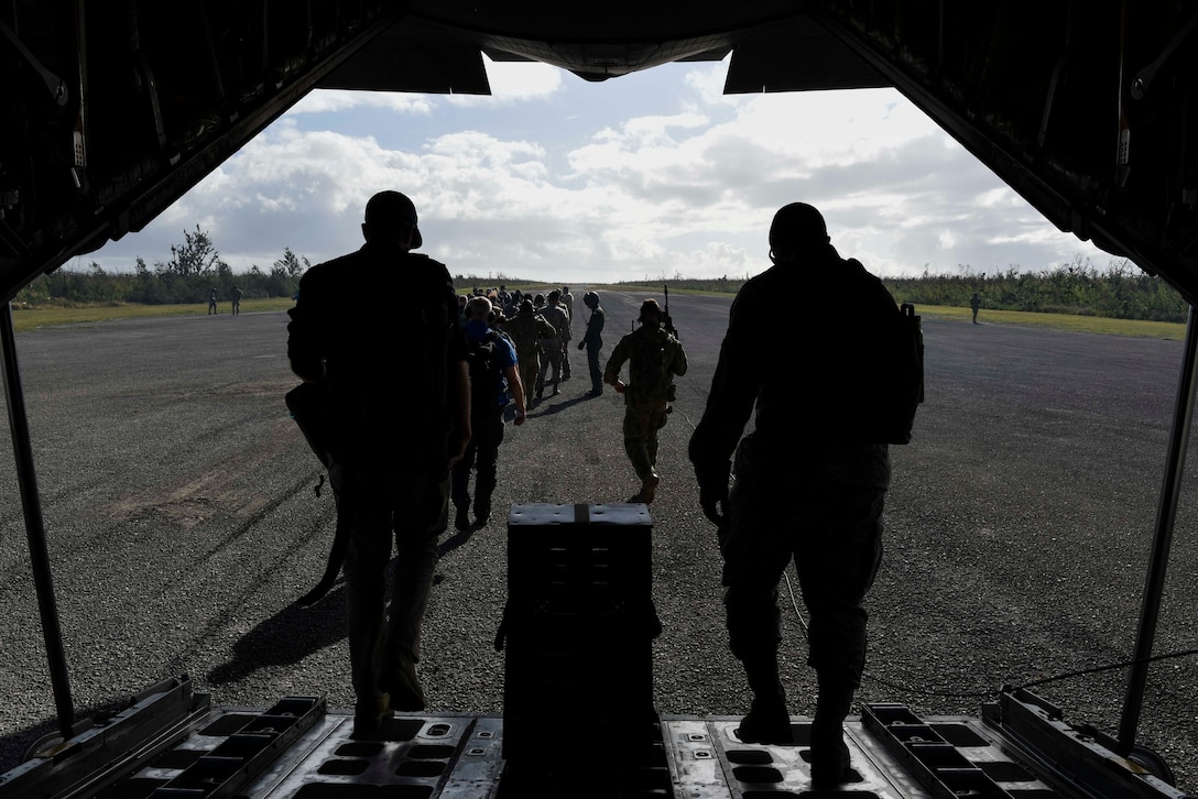 Service members from the United States, Royal Australian Air Force, and the Japan Air Self-Defense Force exit a JASDF C-130H Feb. 27, 2019, at Tinian, Commonwealth of the Northern Marianas. Service members from the U.S., Royal Australian Air Force, and the Japan Air Self-Defense Force exercised their Humanitarian Assistance and Disaster Relief skills together on Tinian by providing emergency medical care and secure transportation for simulated patients. (U.S. Air Force photo by Tech. Sgt. Jake Barreiro)