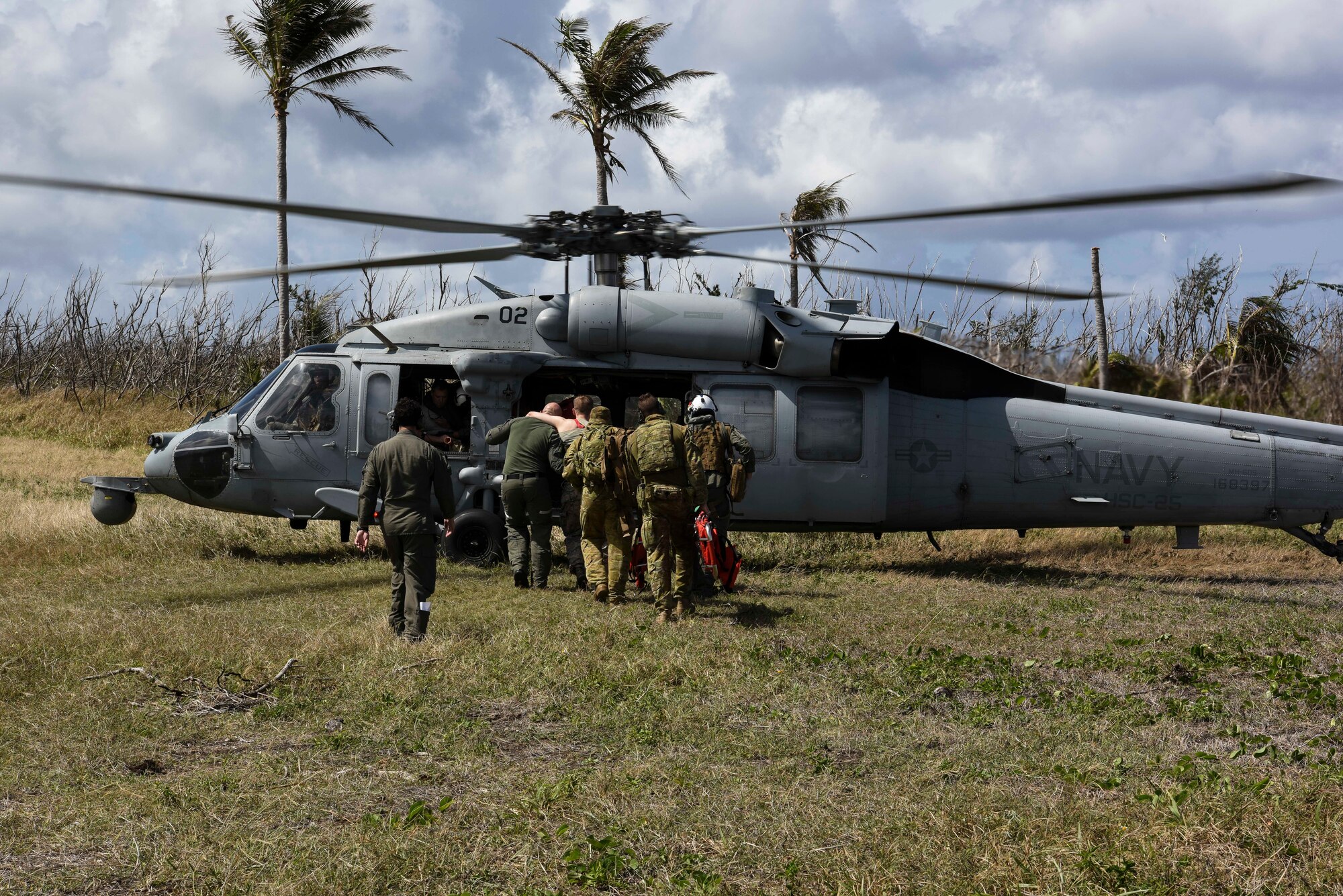Service members from the United States, Royal Australian Air Force, and the Japan Air Self-Defense Force transfer simulated injured personnel to a MH-60 helicopter with the U.S. Navy's Helicopter Sea Combat Squadron 25 during an exercise for Cope North 2019, Feb. 27, 2019, at Tinian, Commonwealth of the Northern Marianas. Service members from the U.S., Royal Australian Air Force, and the Japan Air Self-Defense Force exercised their Humanitarian Assistance and Disaster Relief skills together on Tinian by providing emergency medical care and secure transportation for simulated patients.  (U.S. Air Force photo by Tech. Sgt. Jake Barreiro)