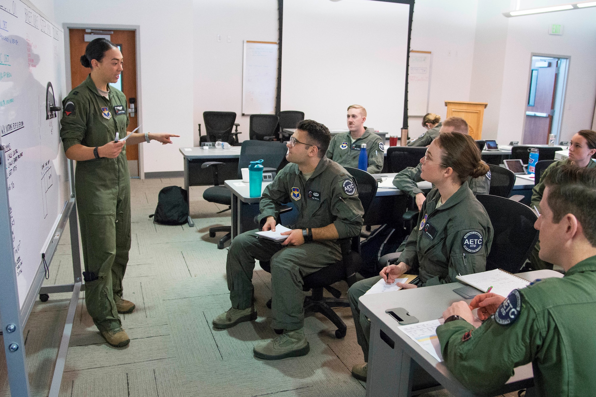 Capt. Christine Durham (left), Pilot Training Next instructor pilot, gives a briefing to her students prior to a training mission at the Armed Forces Reserve Center in Austin, Texas, Feb. 5, 2019. The current PTN class is comprised of 26 students, including 16 active duty officer students (six of whom are participating in a remotely-piloted aircraft only track), two Air National Guard officers, two U.S. Navy officers, one Royal Air Force officer, and five enlisted Airmen. (U.S. Air Force photo by Sean M. Worrell)