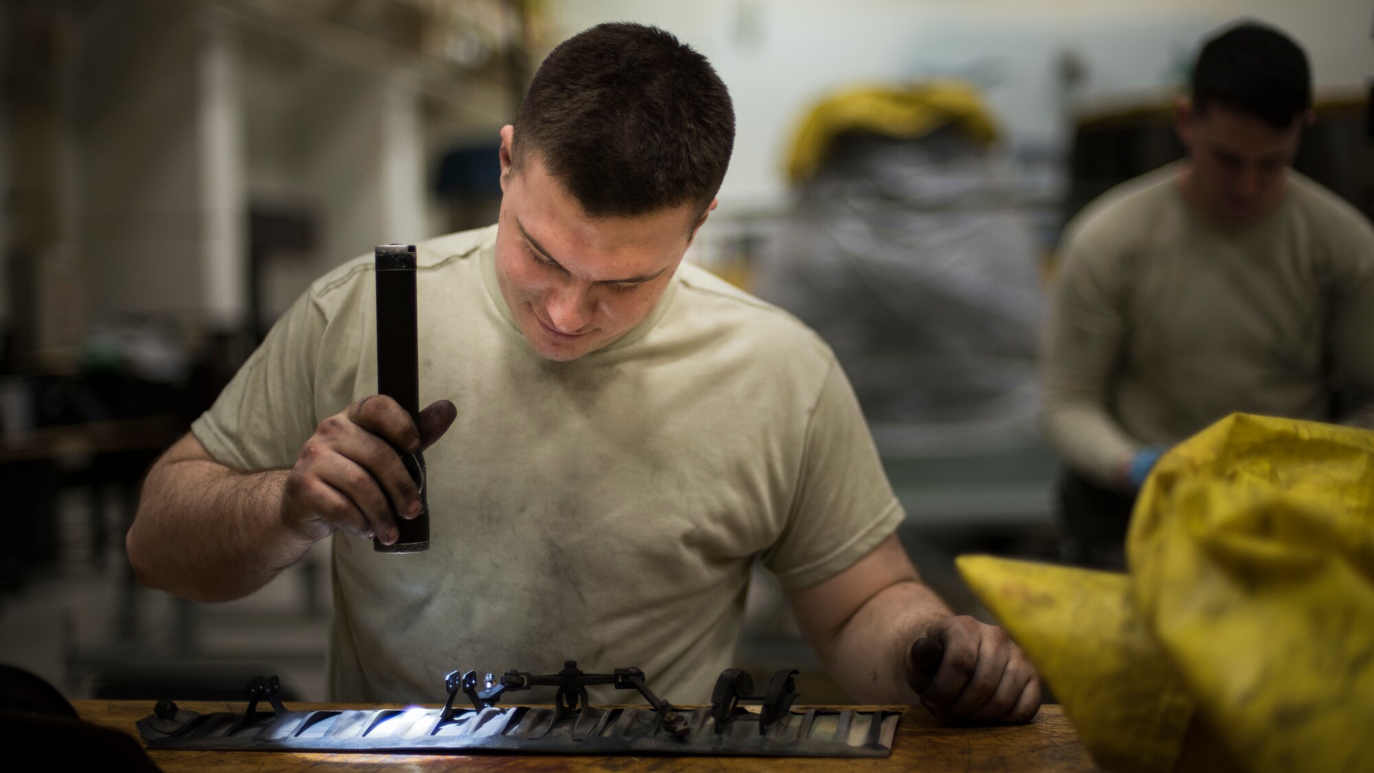 U.S. Air Force Airman 1st Class William Bowen, a 35th Maintenance Squadron aerospace propulsion journeyman, inspects a divergent seal with a flash light at Misawa Air Base, Japan, Feb. 25, 2019. Propulsion Airmen previously traveled across the flightline to access spare parts and materials to complete their mission, but now an easily accessible storage unit is just feet away from their shop location. (U.S. Air Force photo by Airman 1st Class Collette Brooks)