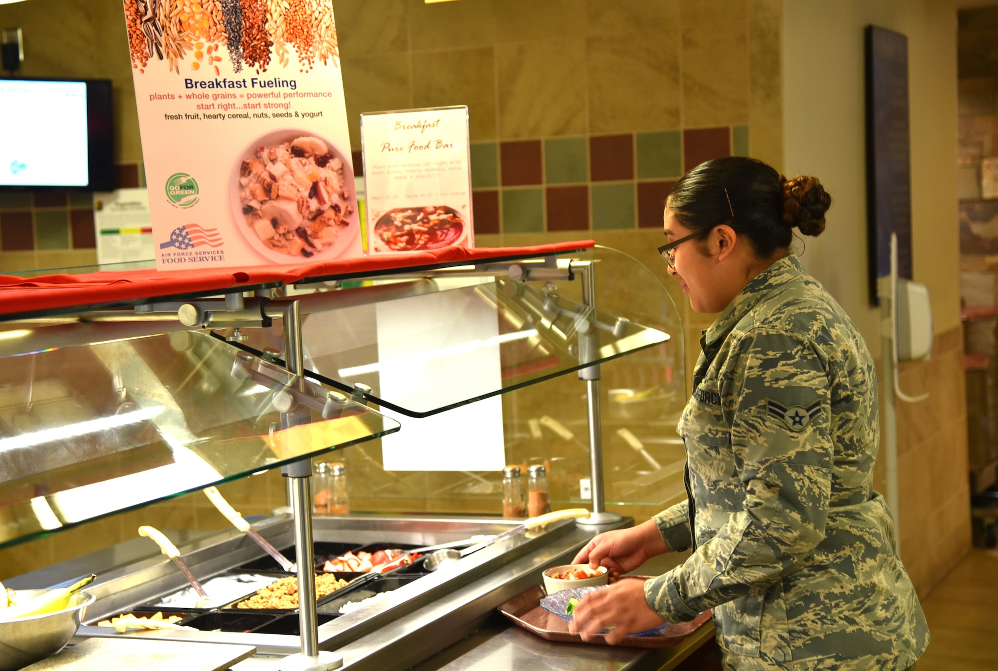 An Airman builds her meal using fresh, health options on the Pure Bar at the Aragon Dining Facility on Peterson AFB, Colorado. Pure Bars, packed with whole grains, fresh fruits and other more nutritional offerings, are part of the Air Force's Go For Green program designed to provide healthy, power fueling for Airmen. (U.S. Air Force photo by Carrie Grover)