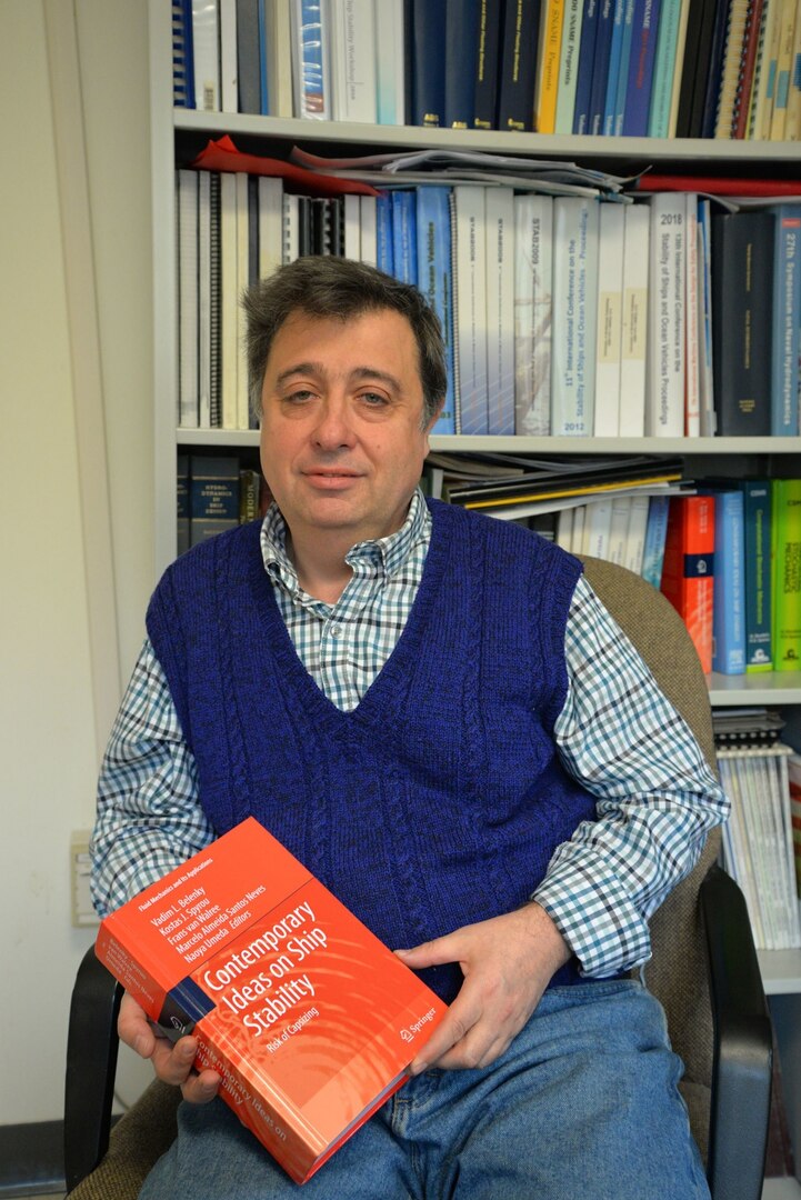 Dr. Vadim Belenky, a naval architect in the Simulations and Analysis Branch at Naval Surface Warfare Center, Carderock Division, holds a copy of Contemporary Ideas on Ship Stability: Risk of Capsizing on Jan. 23, 2019. The book is a compilation of papers from engineers, naval architects and professors from around the world, for which he was the editor in chief. (U.S. Navy photo by Kelley Stirling/Released